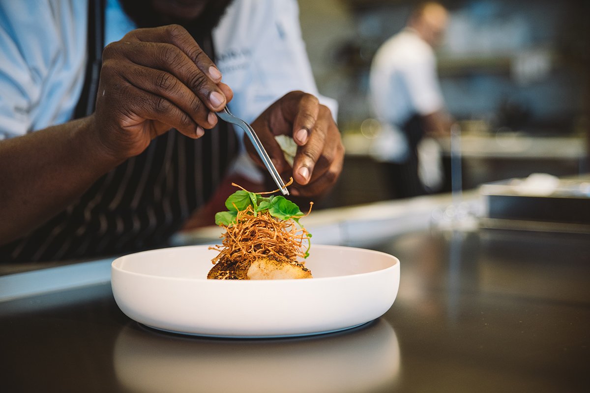 Executive chef preparing a signature dish for a commercial restaurant brand film.