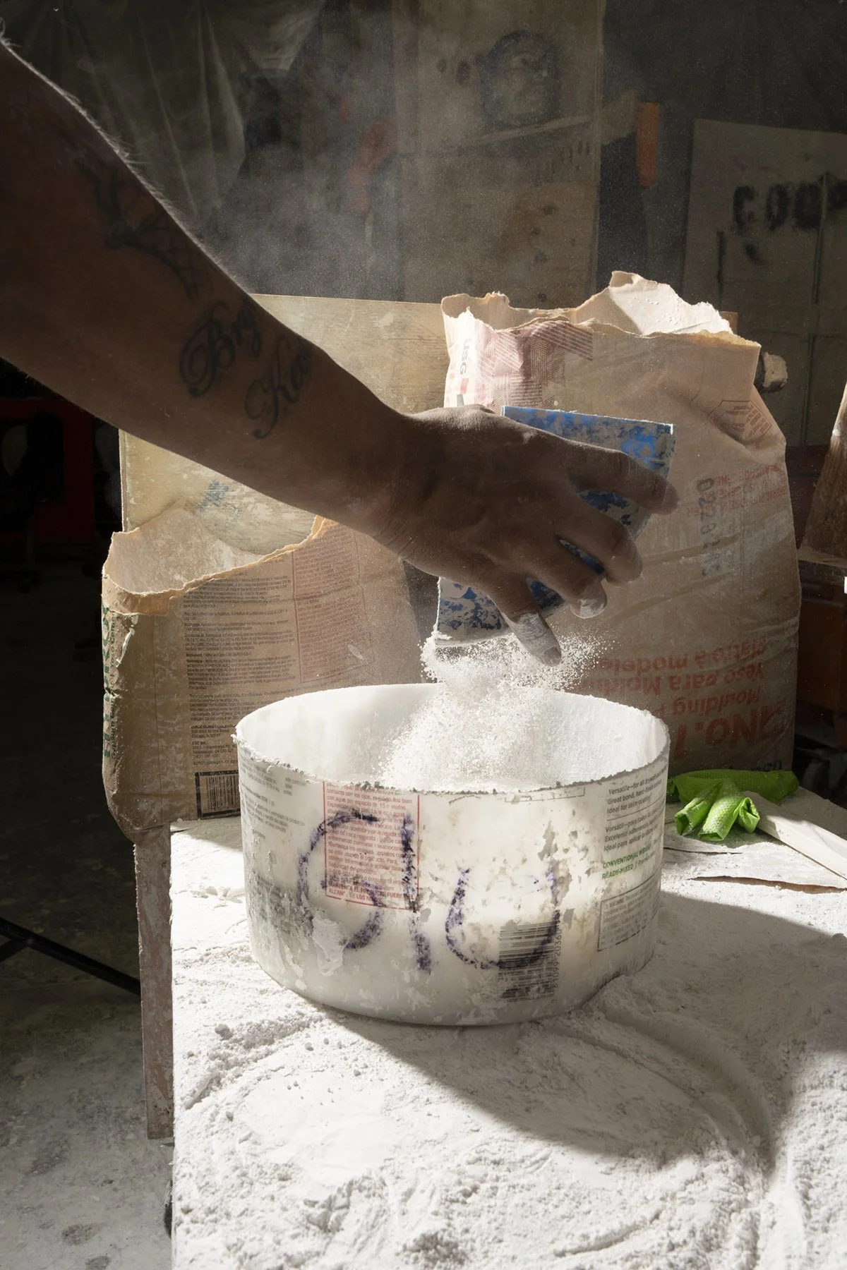 Photography of an artisan mixing plaster documenting the historic renovation of the Waldorf Astoria New York