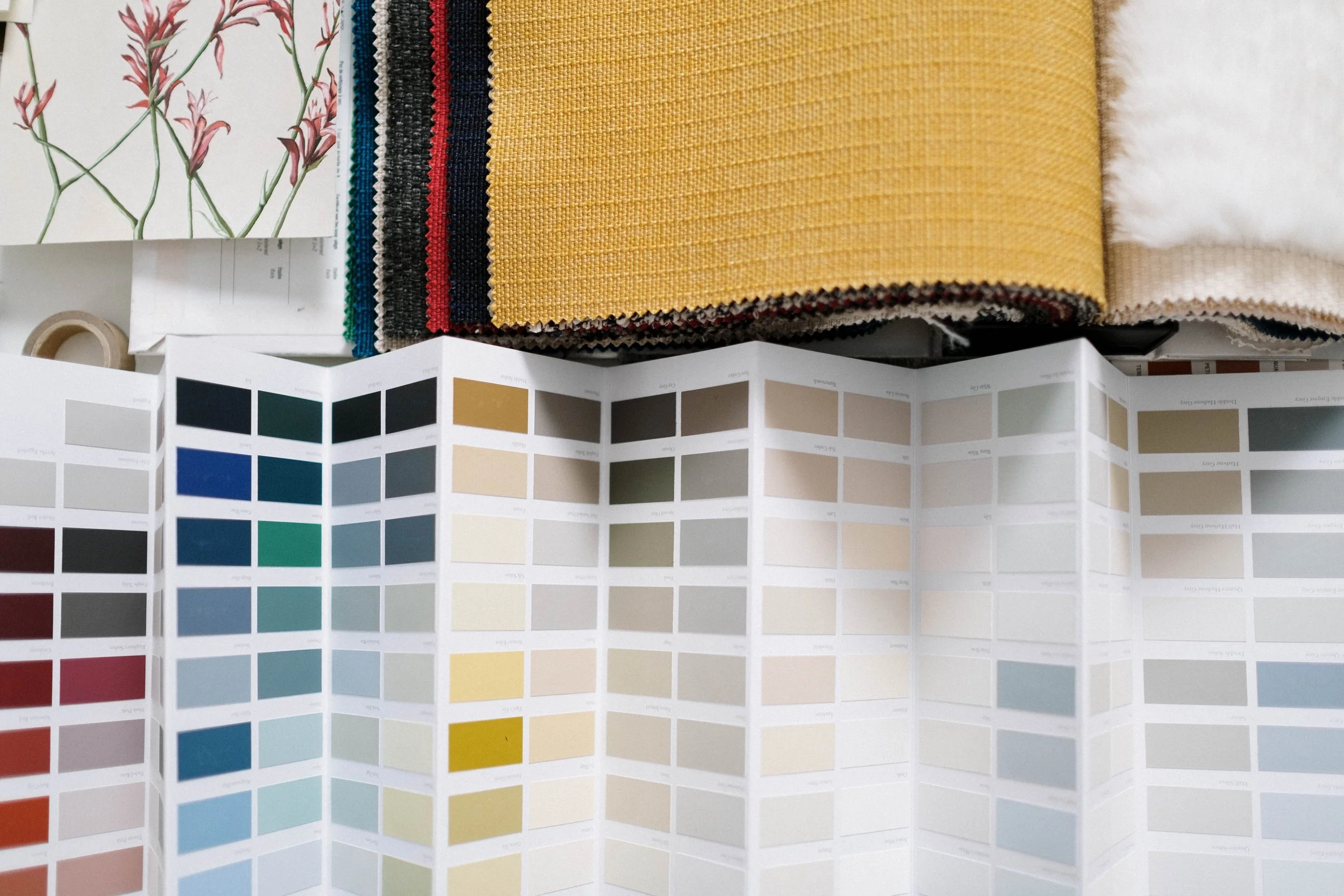Color swatch and fabric samples on table, including various fabric textures and color palette chart.