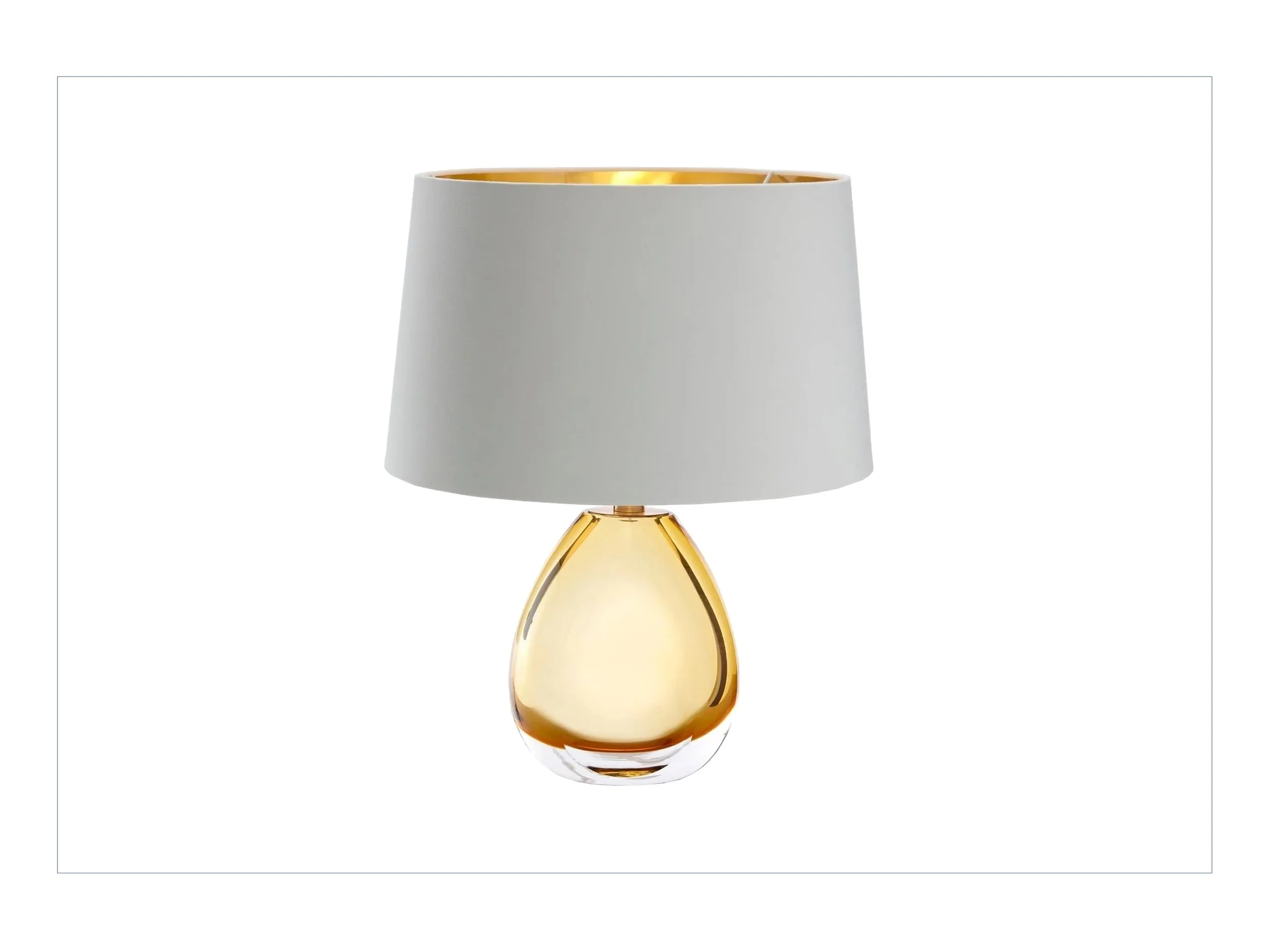 A glass table lamp with a teardrop-shaped base in gold and clear glass, topped with a white fabric lampshade.