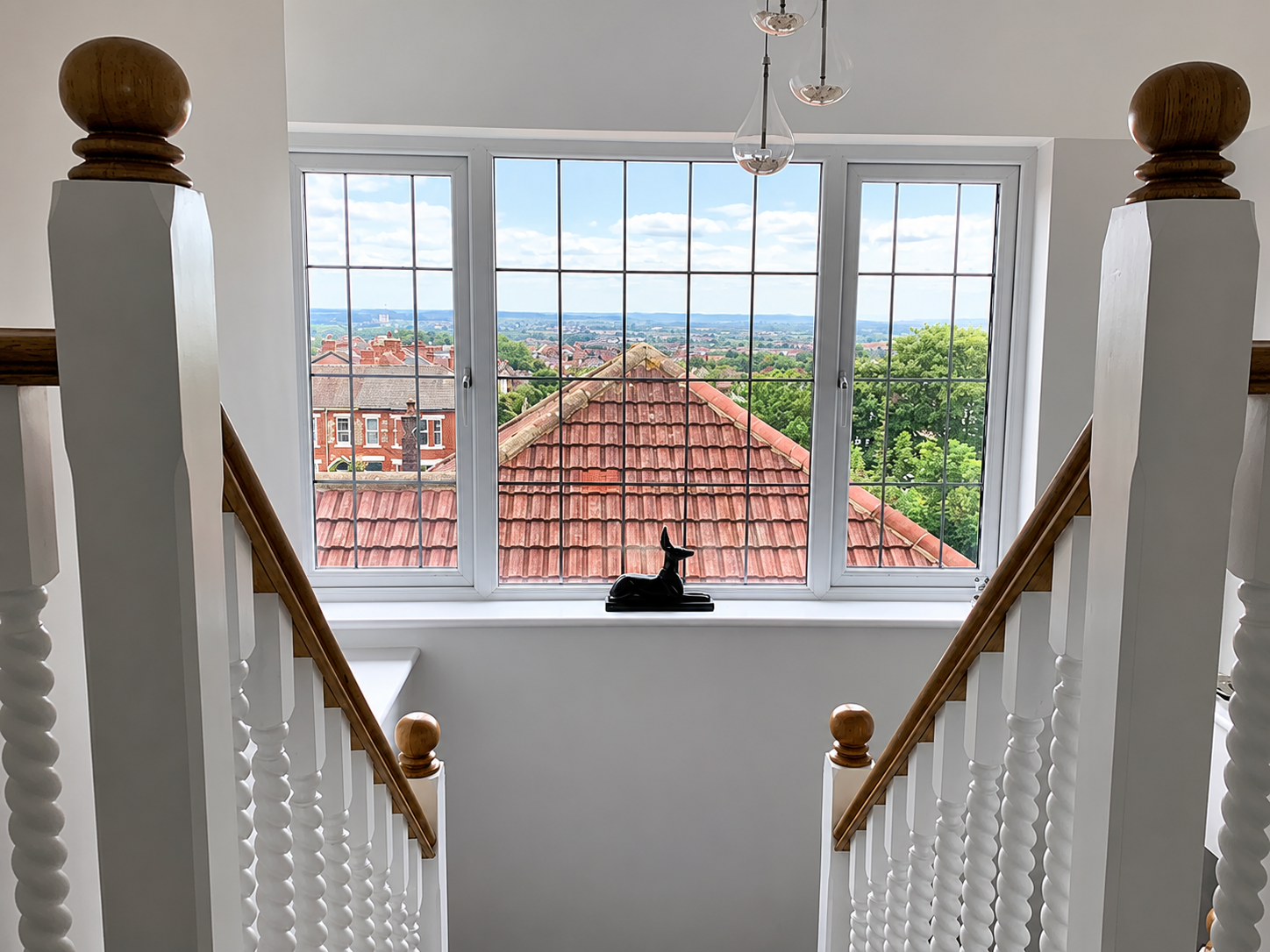Staircase landing with large feature window overlooking Wirral