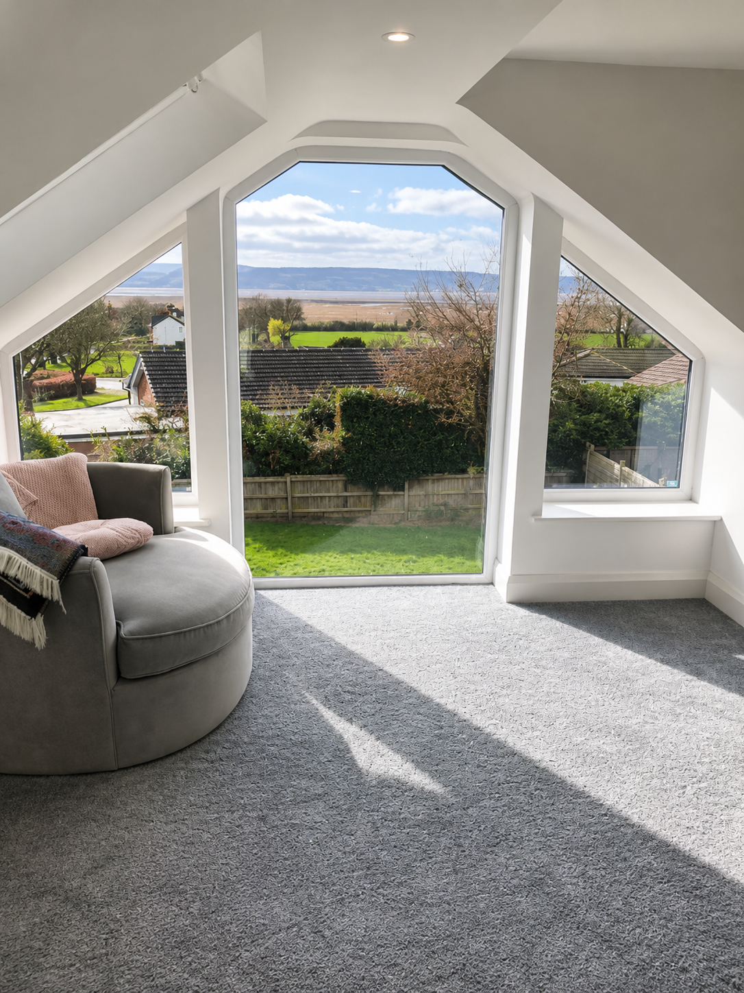 Loft conversion room with bespoke floor-to-ceiling feature window overlooking the countryside