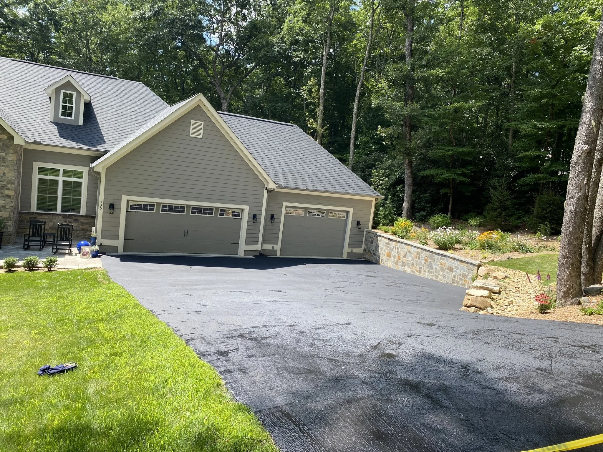 Freshly sealcoated asphalt driveway at a large home in Cashiers, NC — sealcoating by Black Bear Paving