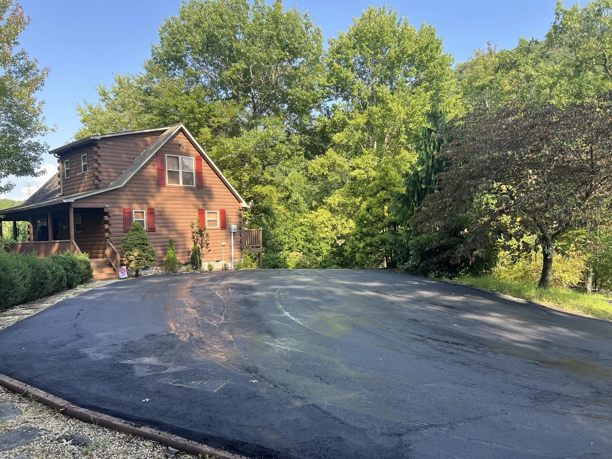 New asphalt driveway and parking area at a mountain log home in Bryson City, NC, paved by Black Bear Paving