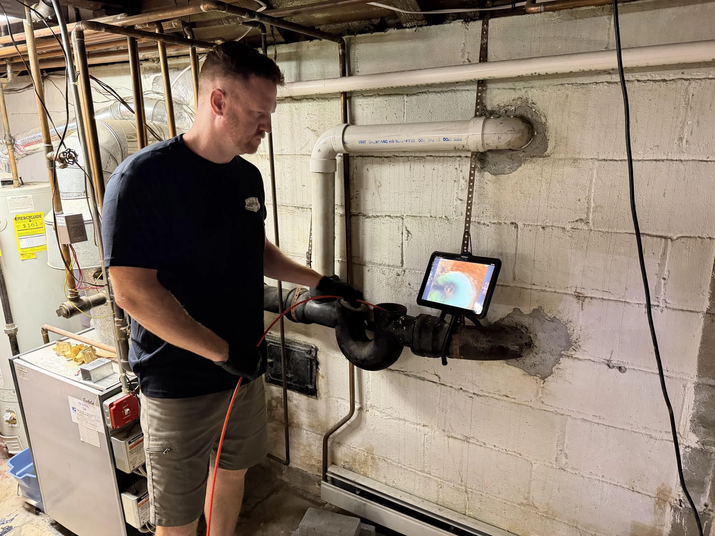 Technician performing a sewer camera inspection through a basement cleanout in Massapequa, NY
