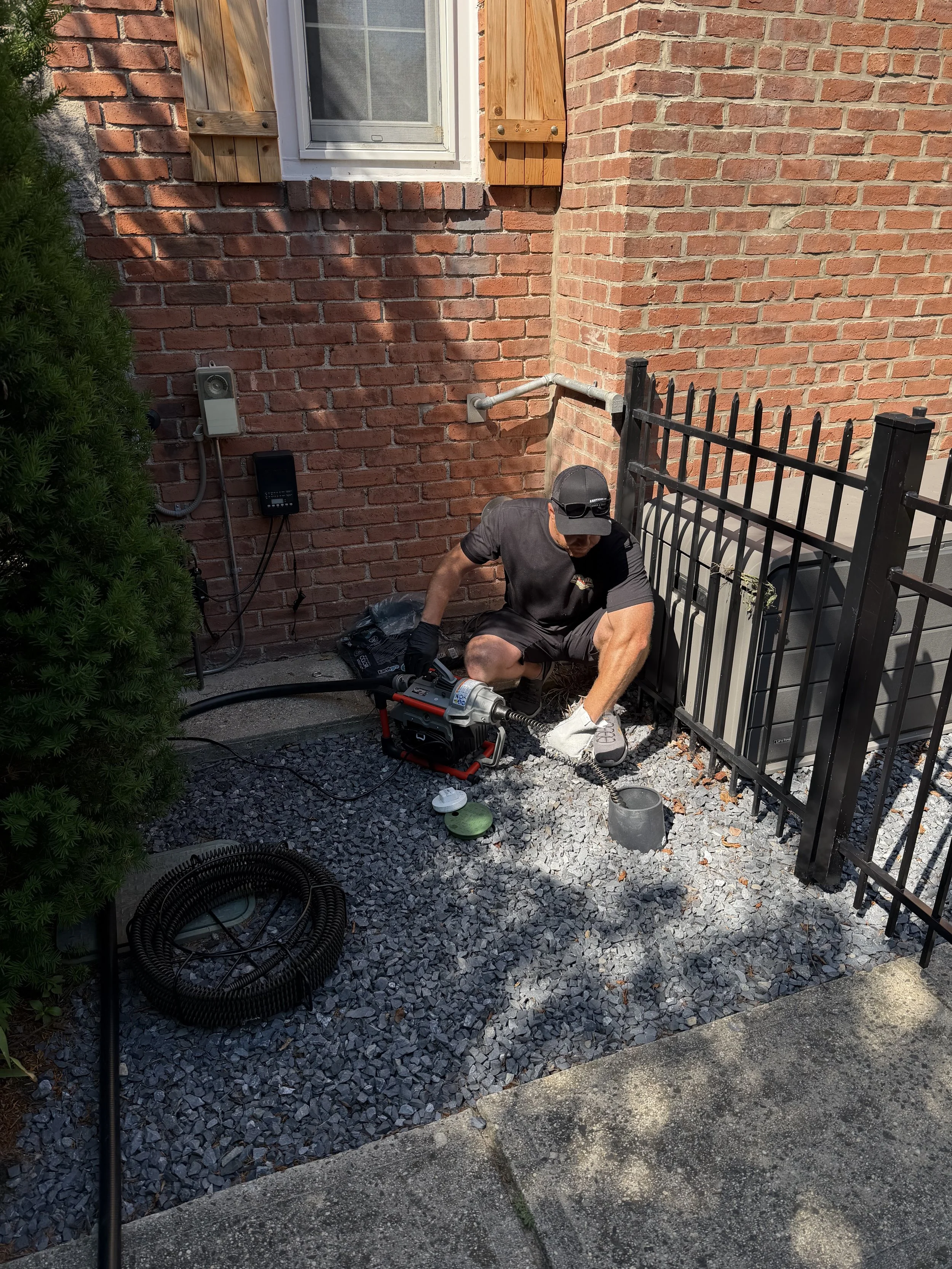 Technician using a sectional drain cleaning machine at a home in Amityville, NY