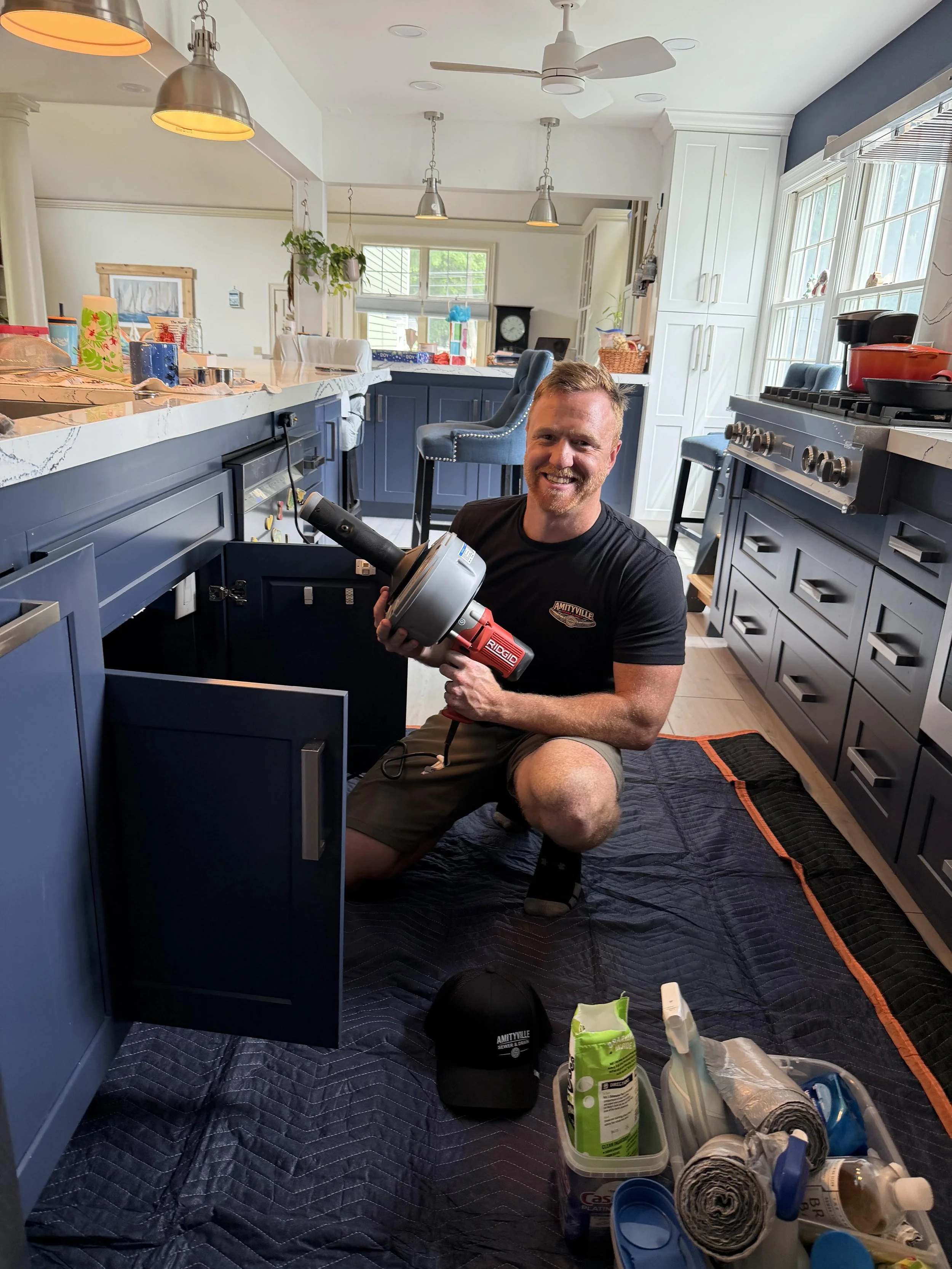 Amityville Sewer & Drain technician using a RIDGID drain cleaning machine in Copiague, NY