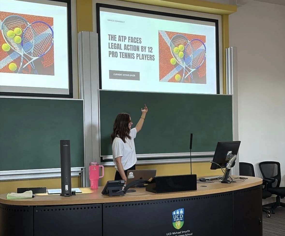 UCD Smurfit MDP student delivering a current affairs presentation in a lecture theatre, pointing to a projected slide