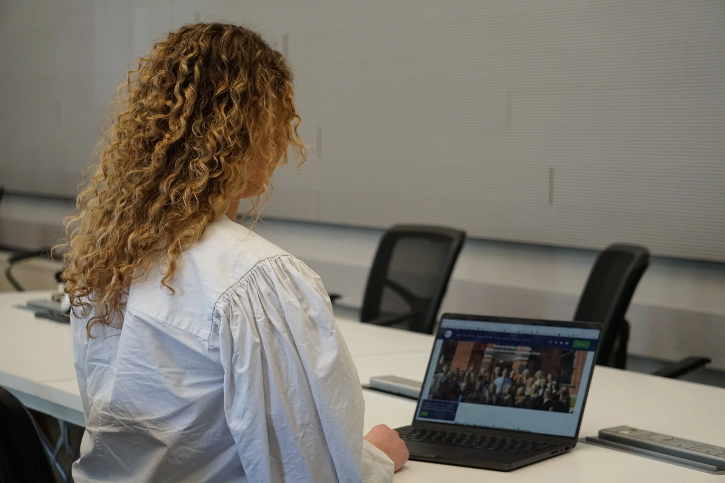 UCD Smurfit MDP student reviewing the programme website on a laptop in a campus seminar room