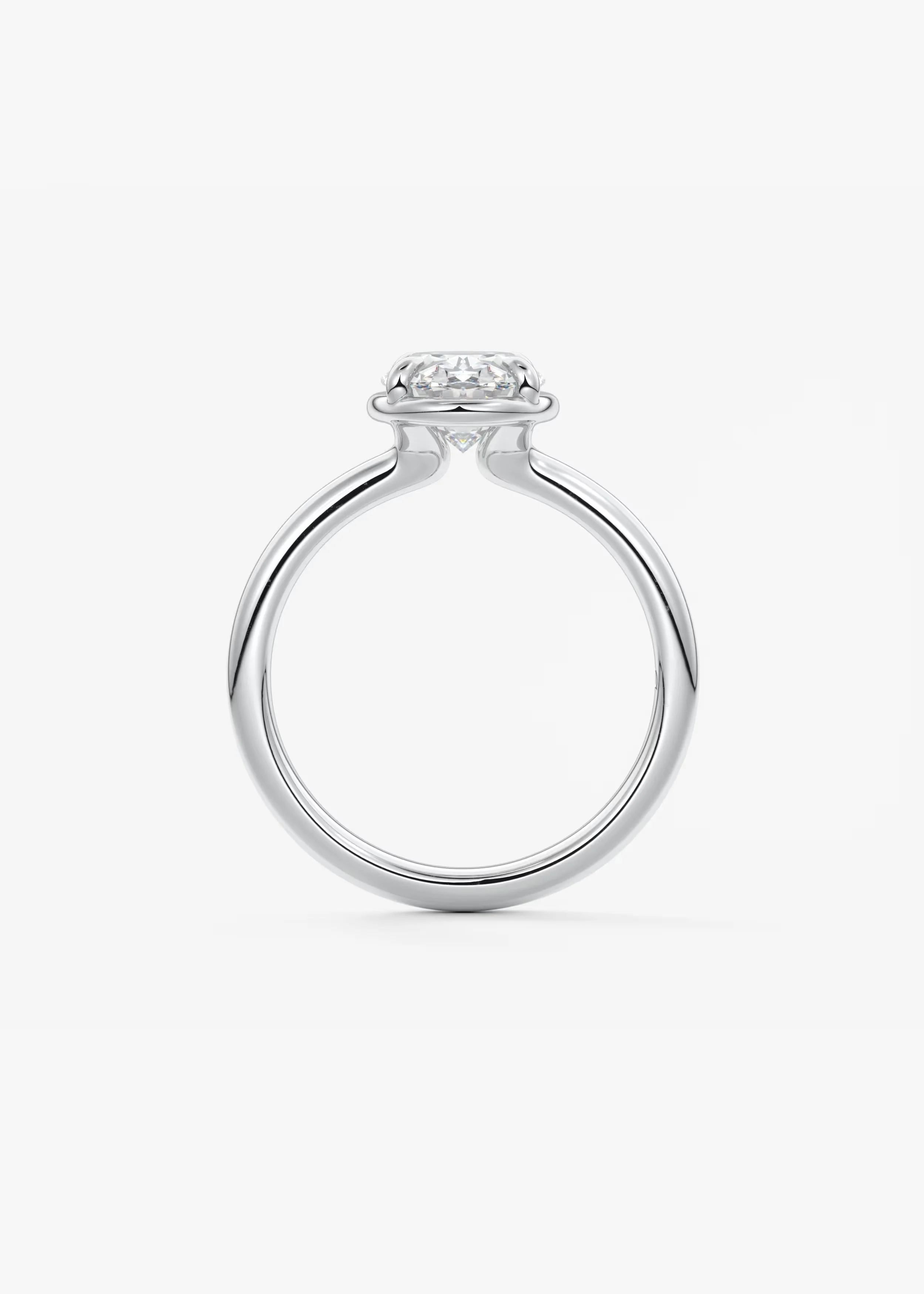 Ein Verlobungsring mit einem großen runden Diamanten in einer Zarge auf einem weißen Hintergrund.