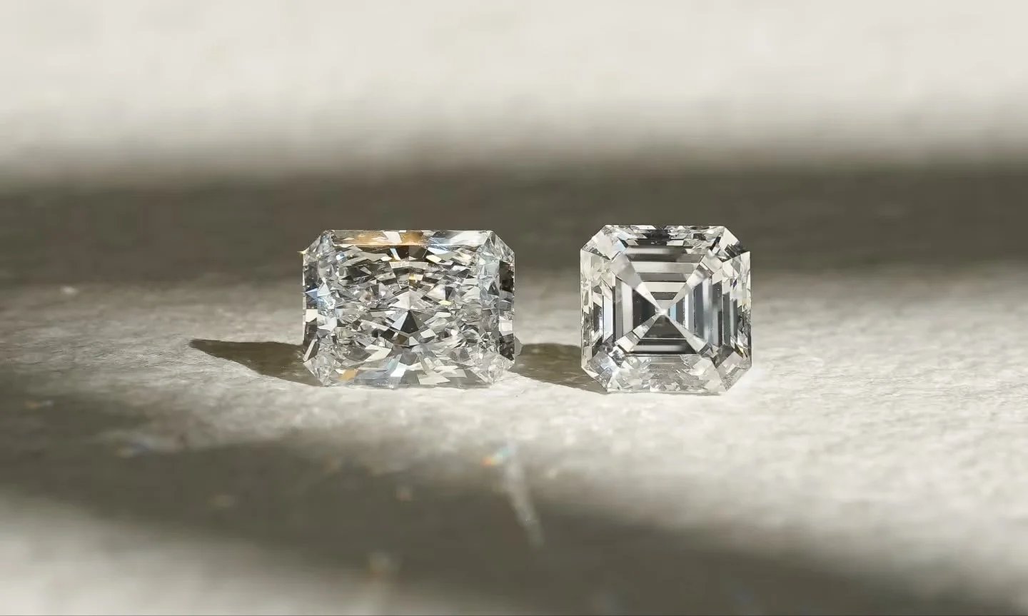 Zwei lose Labordiamanten in Kissen- und Asscher-Schliff auf hellem Untergrund