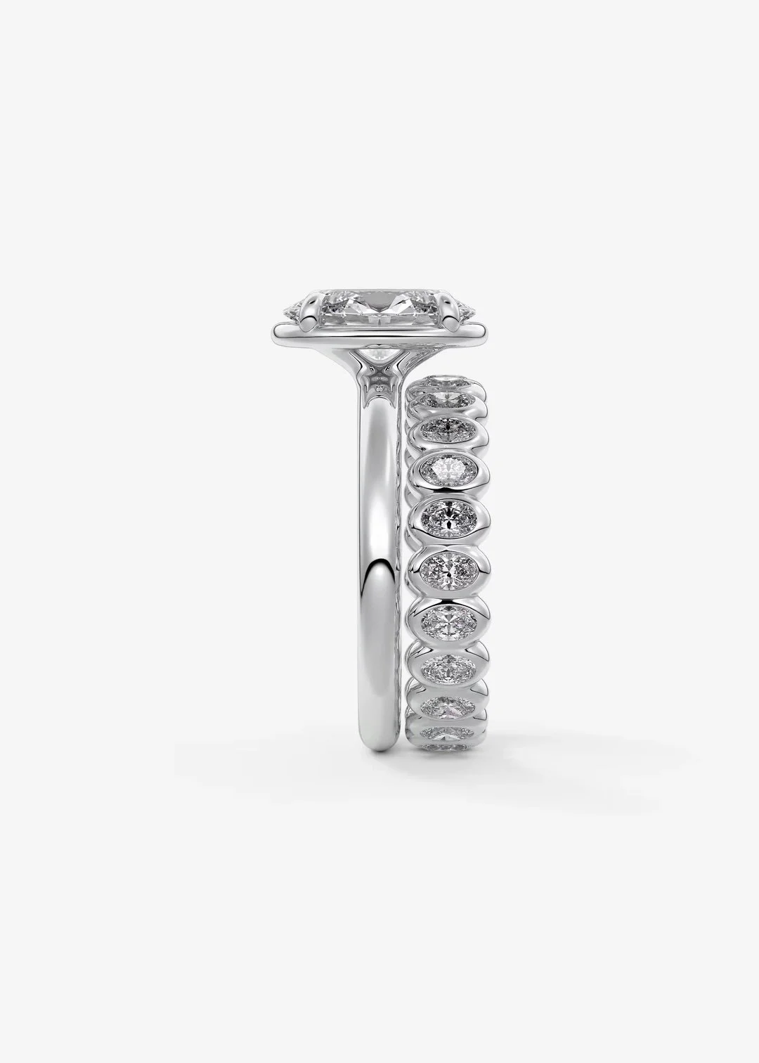 Zwei elegante Ringe, ein mit einem großen Diamanten und der andere mit mehreren kleinen Diamanten, aus Weißgold gefertigt, vor einem weißen Hintergrund.