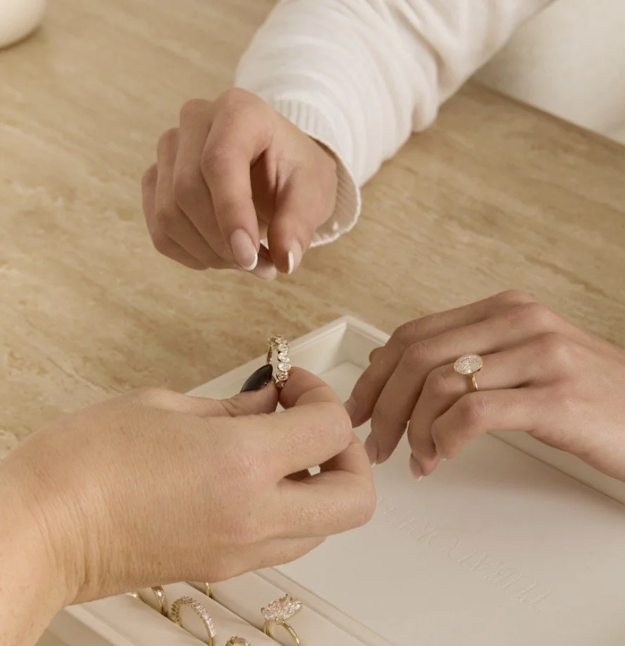 Hände bei der Ringauswahl aus mehreren Modellen während einer Schmuckberatung im Atelier