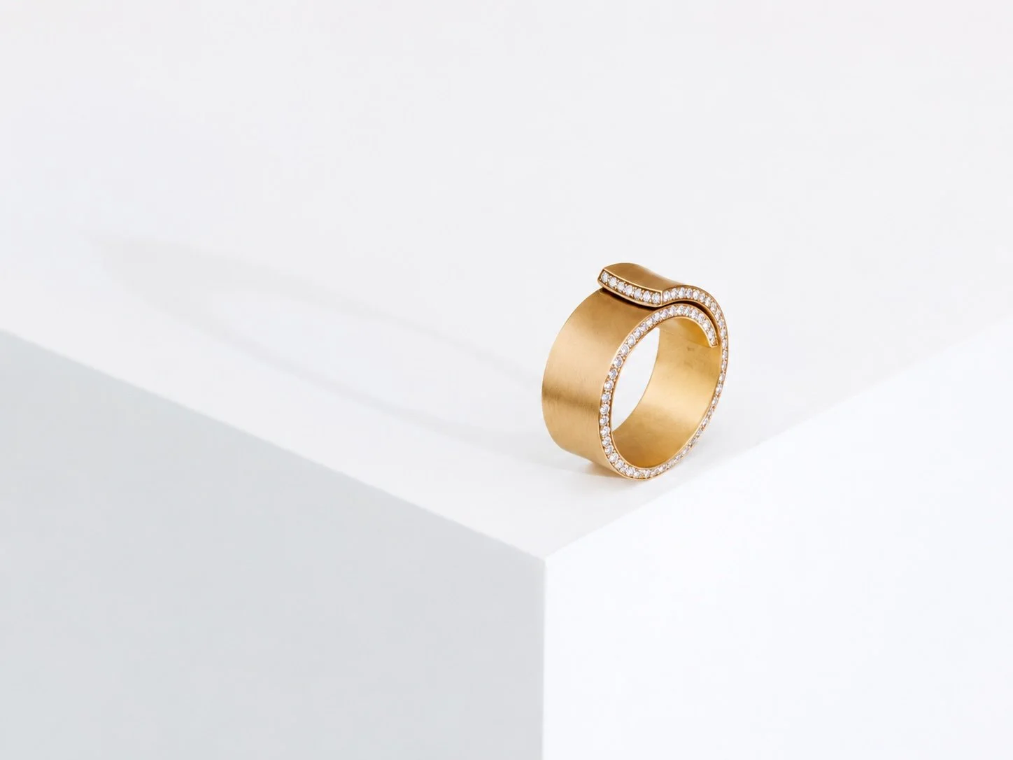 Moderner goldener Ring mit Diamanten auf weißem Hintergrund