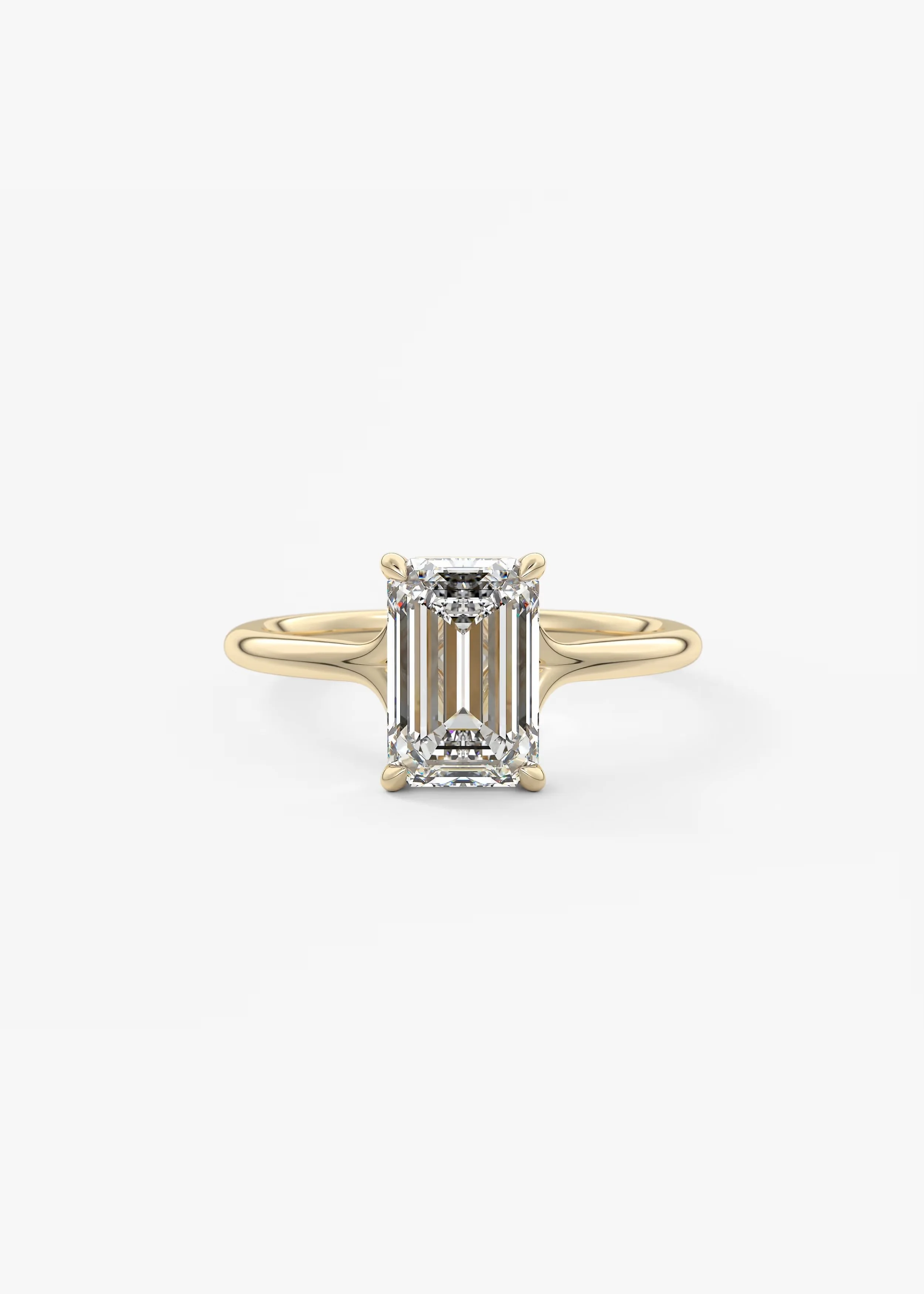 Ein goldener Verlobungsring mit einem großen rechteckigen Diamanten in einem Platin-Krappenfassung, auf weißem Hintergrund.