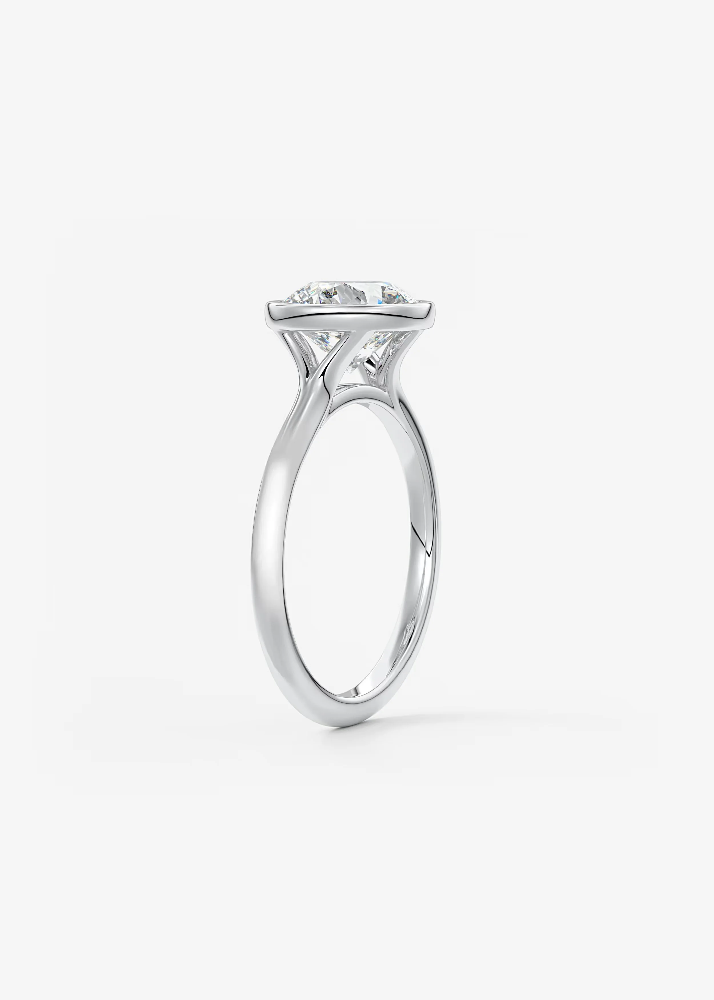 Ein Diamantring mit einem großen, runden Diamanten in einer halbrunden Fassung aus Weißgold, auf weißem Hintergrund.