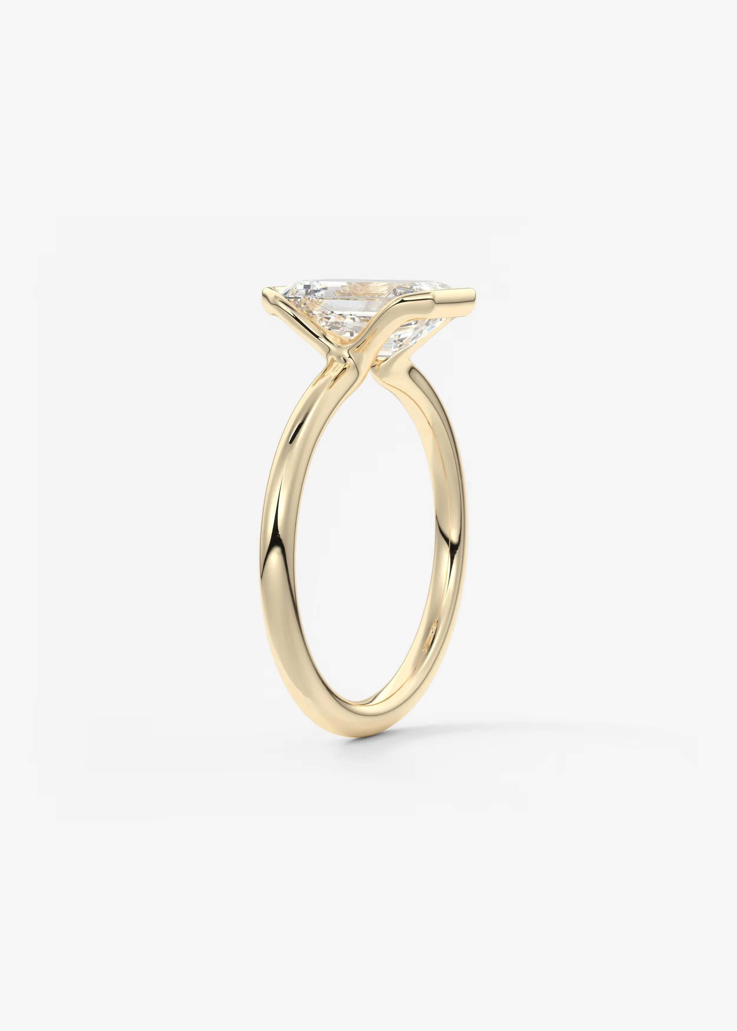 Goldring mit großem, rundem Diamanten in Zargenfassung auf weißem Hintergrund.