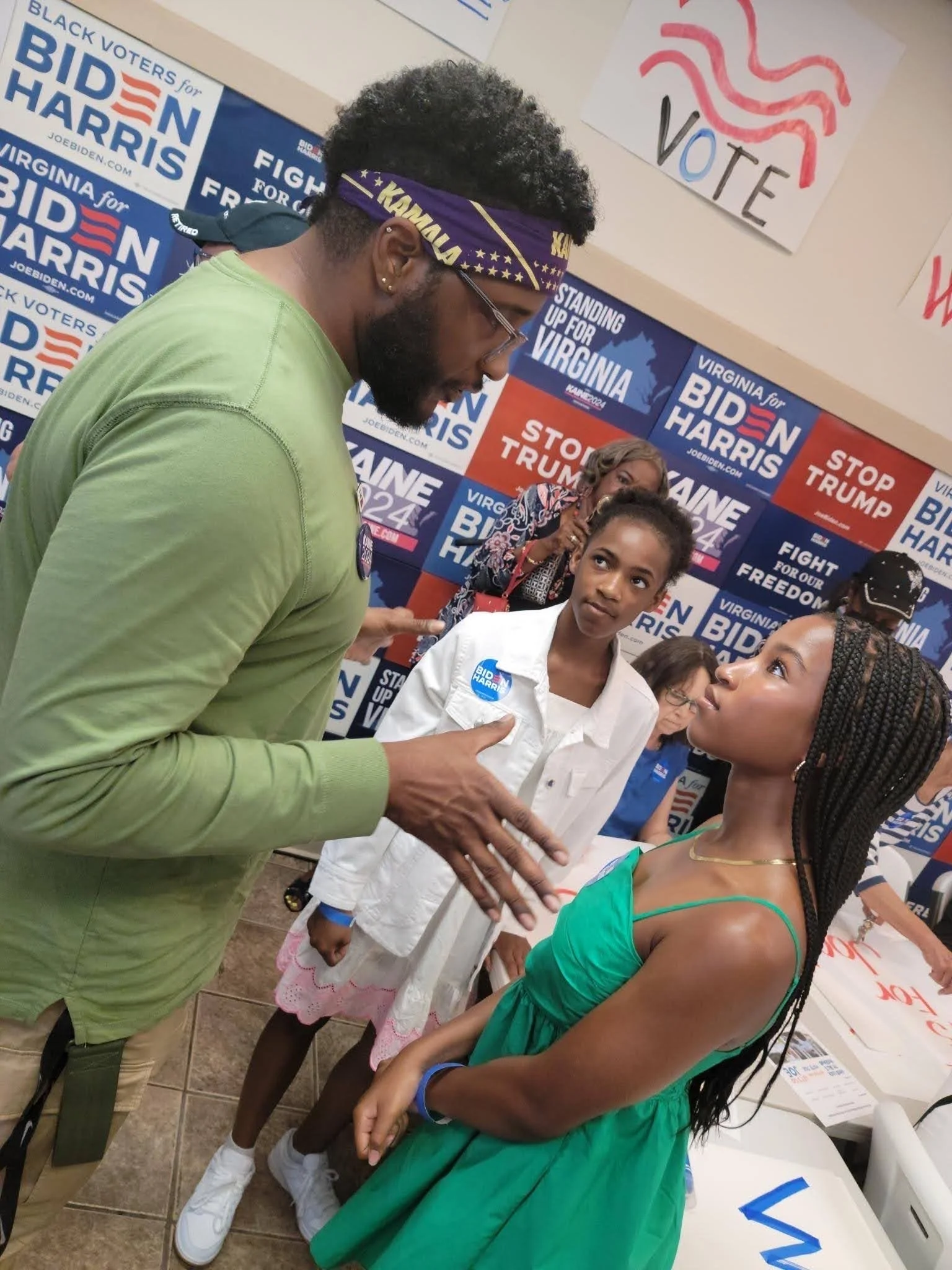 DeNiro Jones speaking with two young Black girls at a presidential campaign event in Virginia.