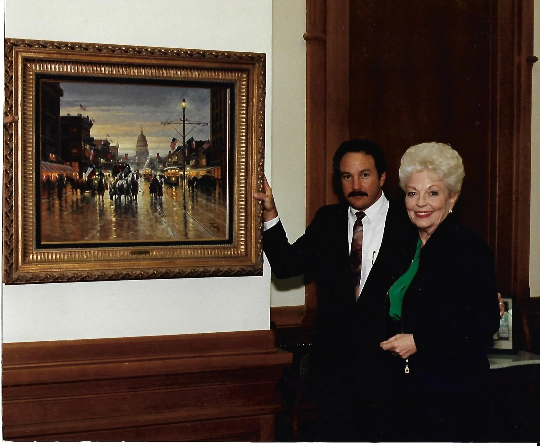 Jack Terry standing beside one of his paintings with former Texas Governor Ann Richards.