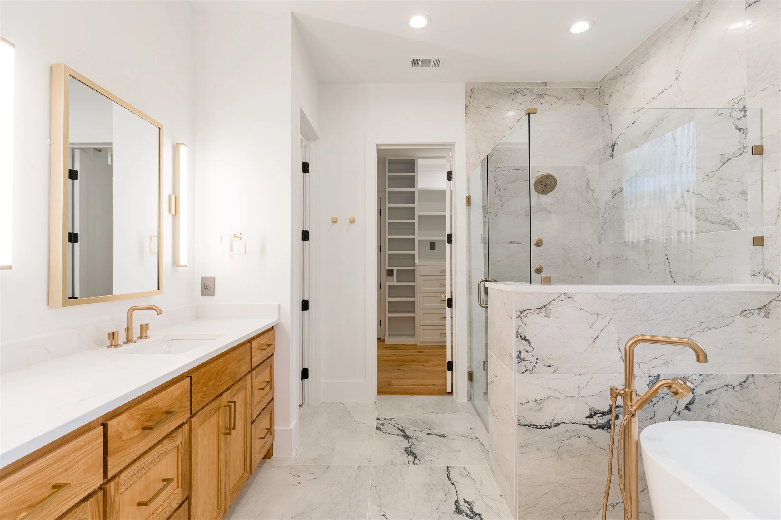 Primary bathroom vanity and marble shower at 13510 Crestmoor Dr.