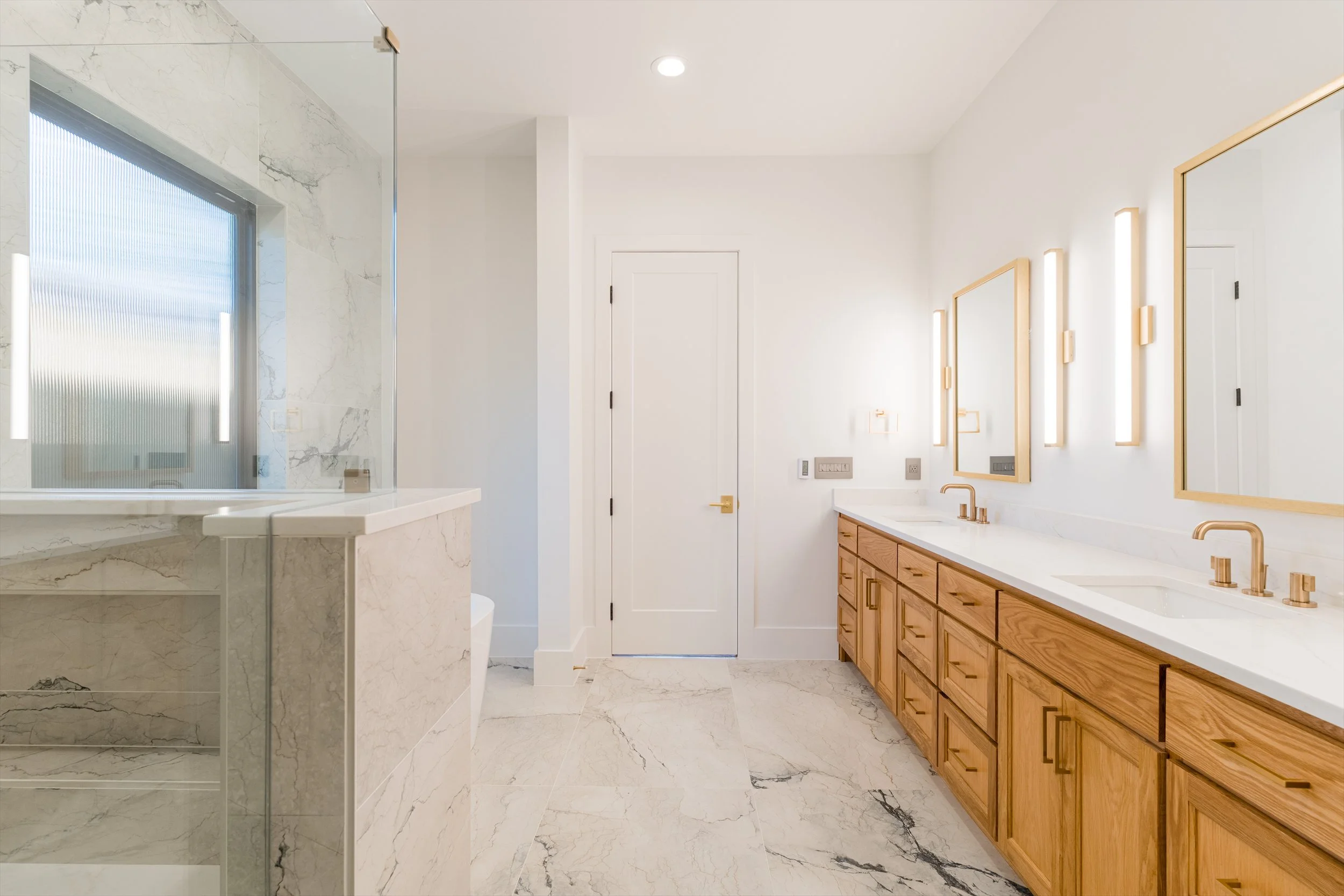 Primary bathroom with marble shower and tub at 13510 Crestmoor Dr.