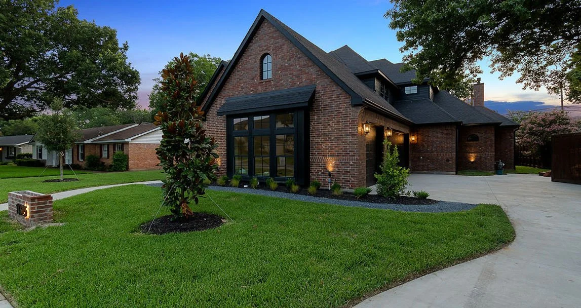 Angled front exterior of 14625 Southern Pines Dr brick custom home in Farmers Branch, Texas