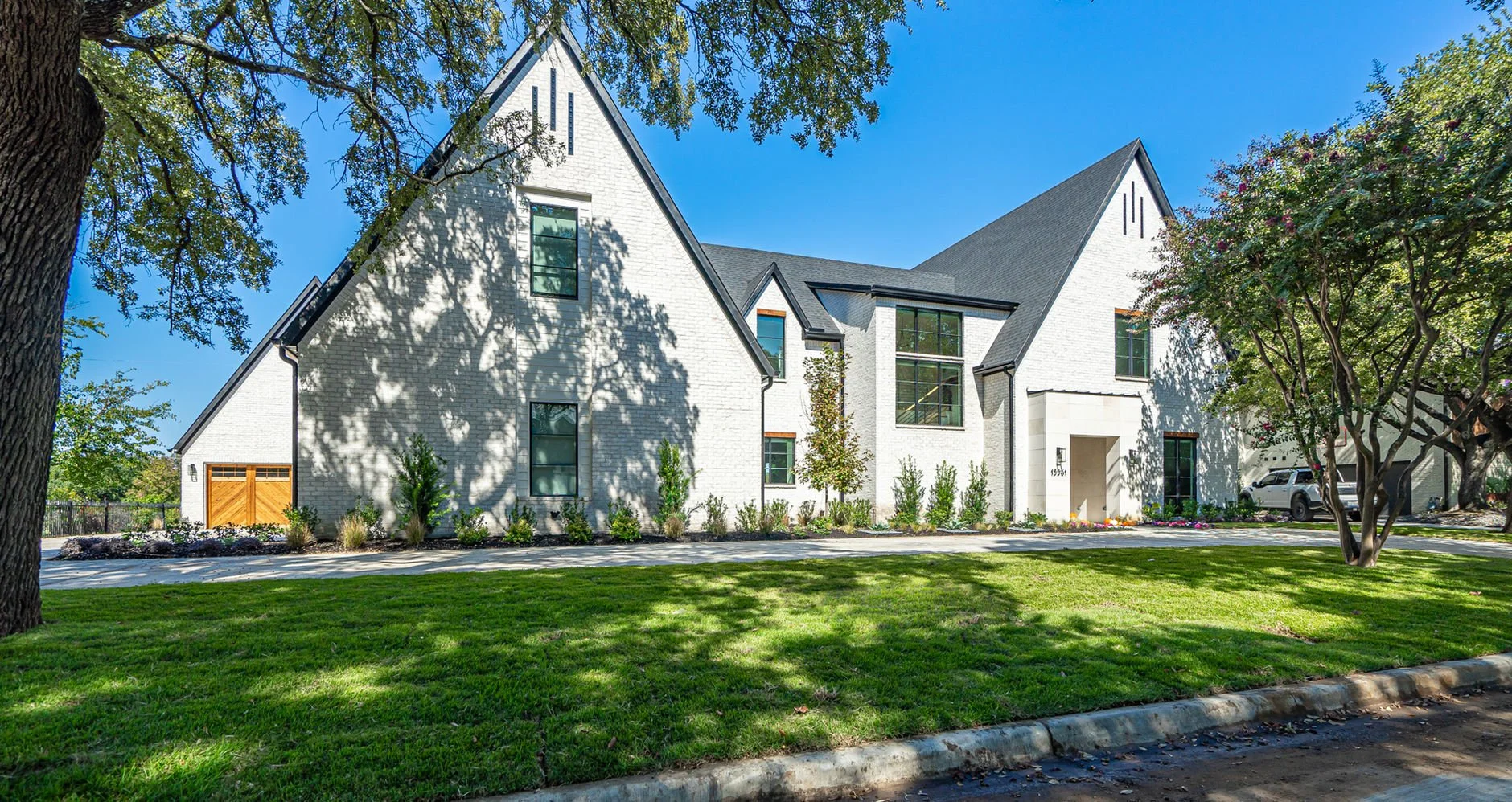 Wide front exterior of 13561 Braemar Dr custom home in Farmers Branch, Texas