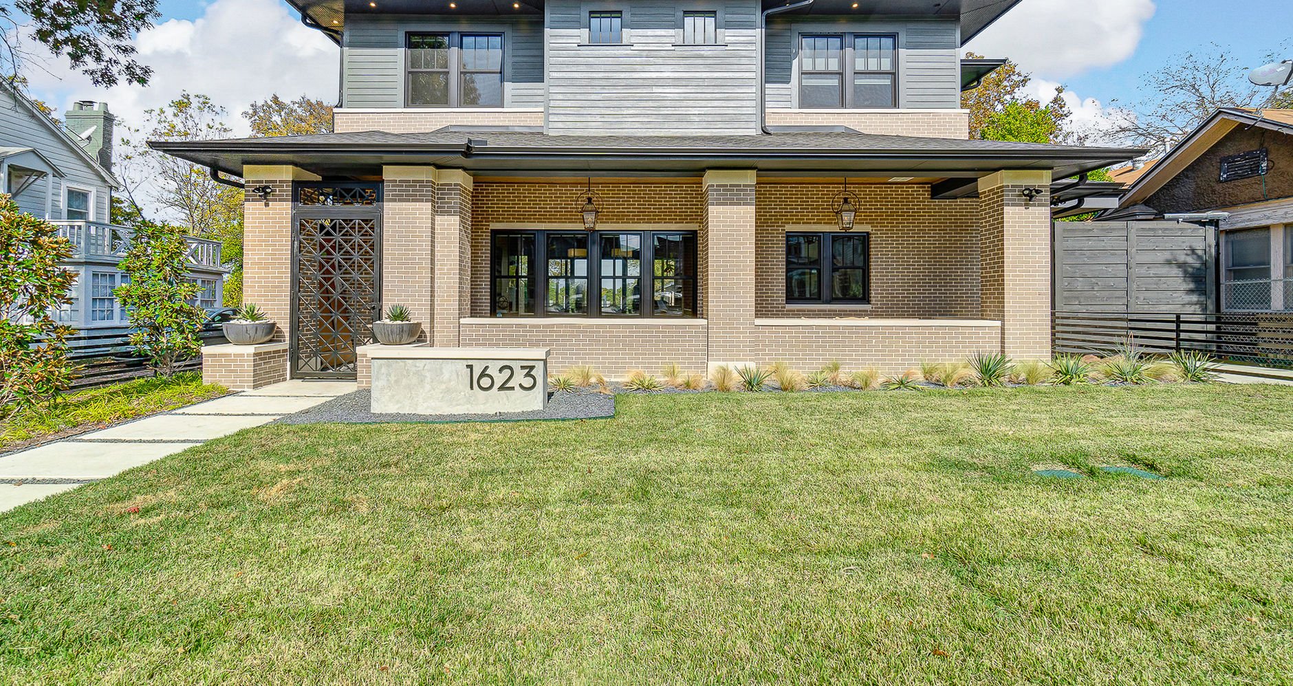 Rear exterior of Prairie-style home at 1623 King’s Hwy with lawn and covered patio in Dallas, Texas