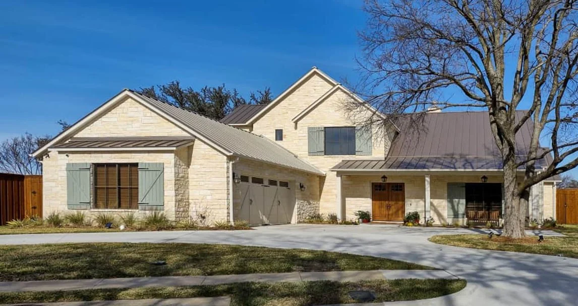 Stone facade and metal roof of 3309 Rolling Knoll custom home in Farmers Branch, Texas
