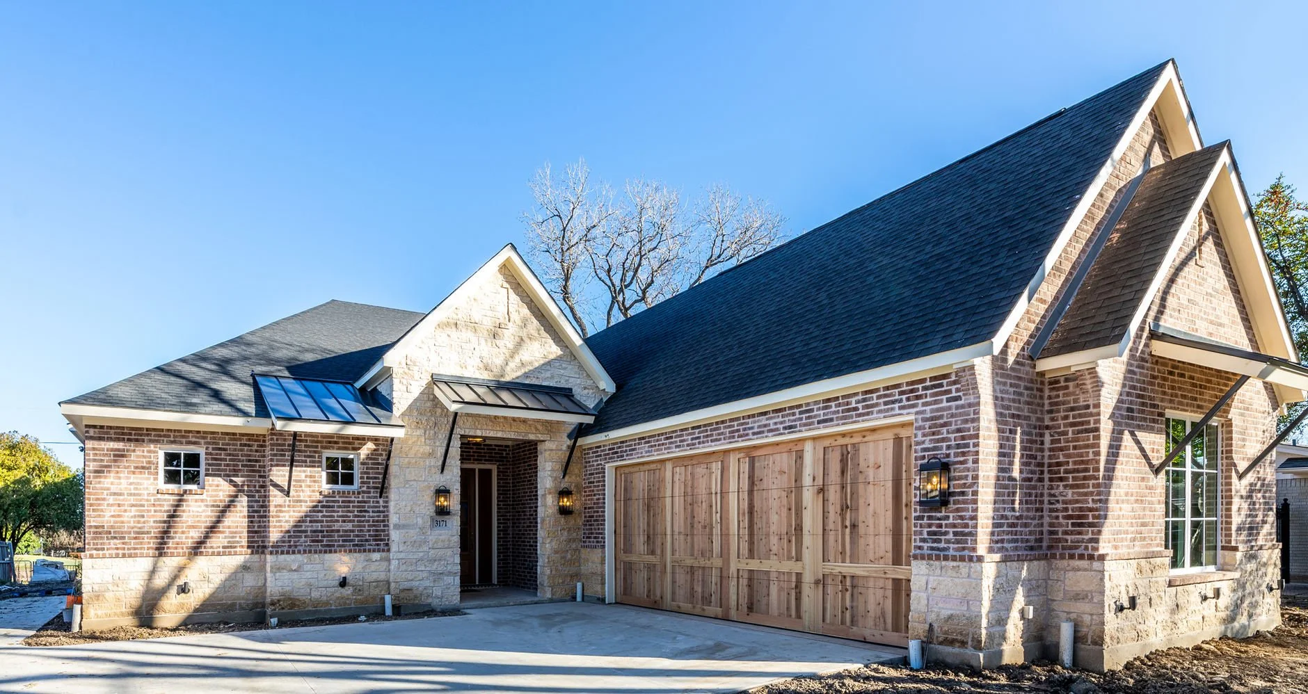 Brick facade and covered entry of 3171 Golfing Green Dr custom home in Farmers Branch, Texas