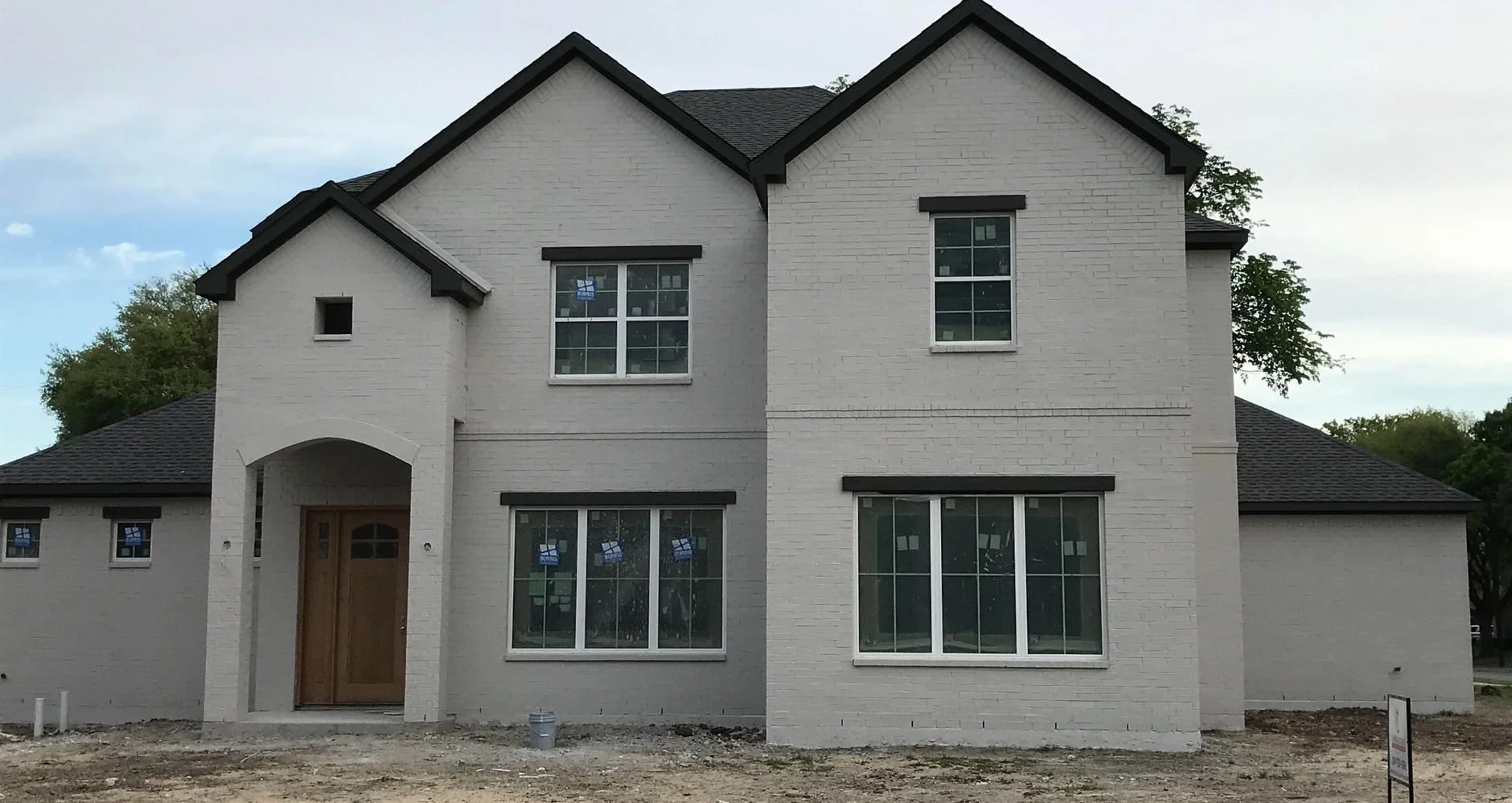 Two-story brick front elevation of 3127 Pebble Beach Dr custom home in Farmers Branch, Texas