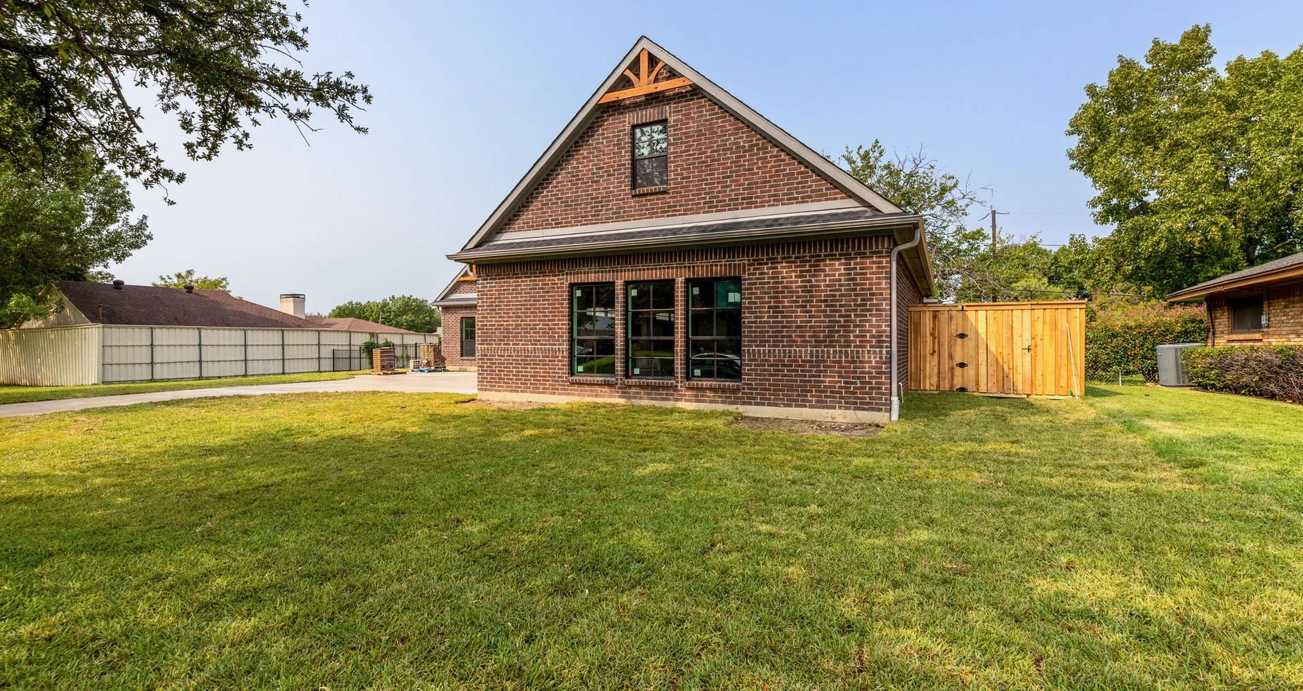 Front exterior and three-car garage of 14311 Tanglewood Dr custom home in Farmers Branch, Texas