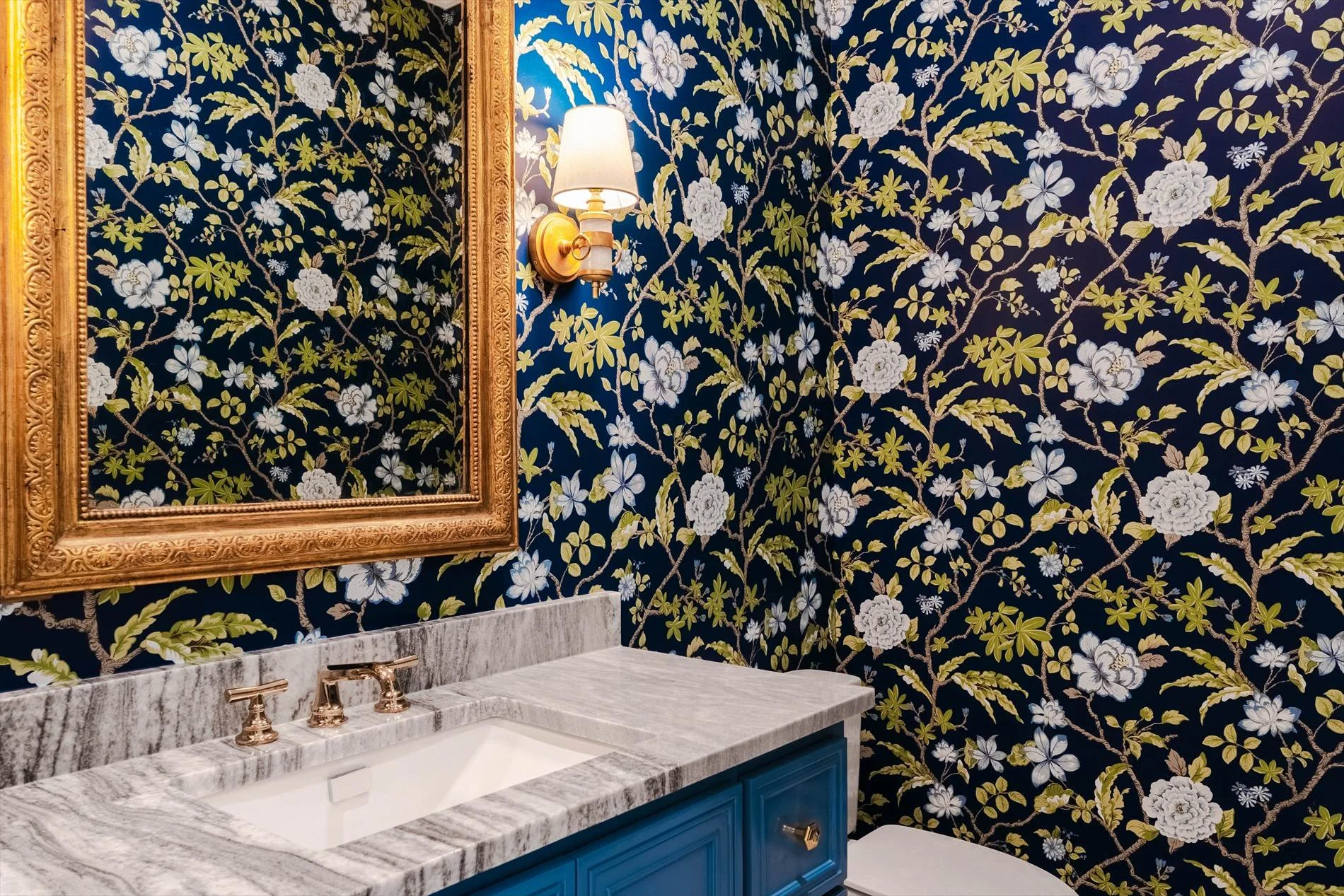  Floral wallpaper, marble vanity, and brass fixtures in a bathroom at 1095 Lathrop Dr custom home in Dallas, Texas 
