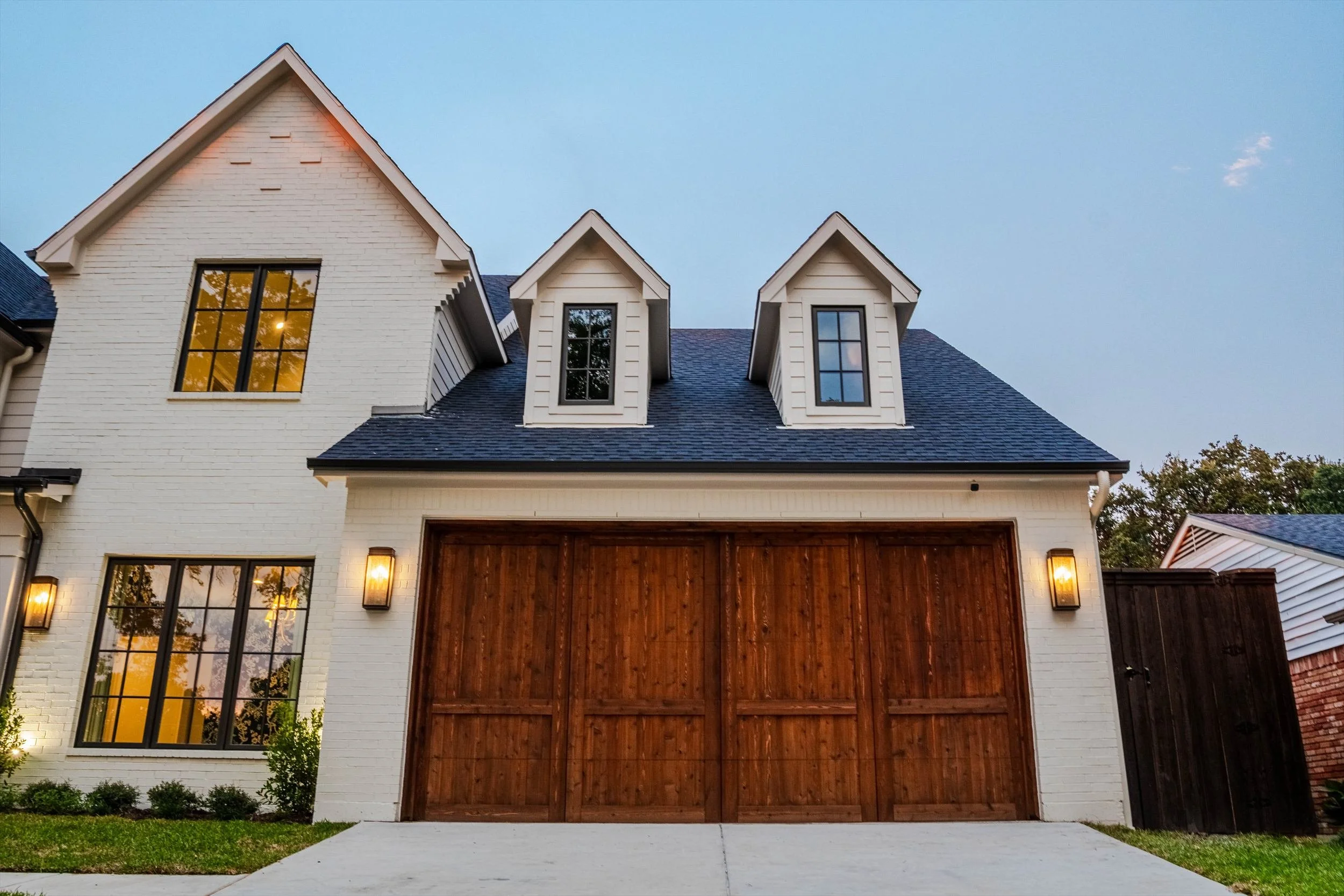 Front driveway and wood garage doors beneath gabled rooflines at 1095 Lathrop Dr.