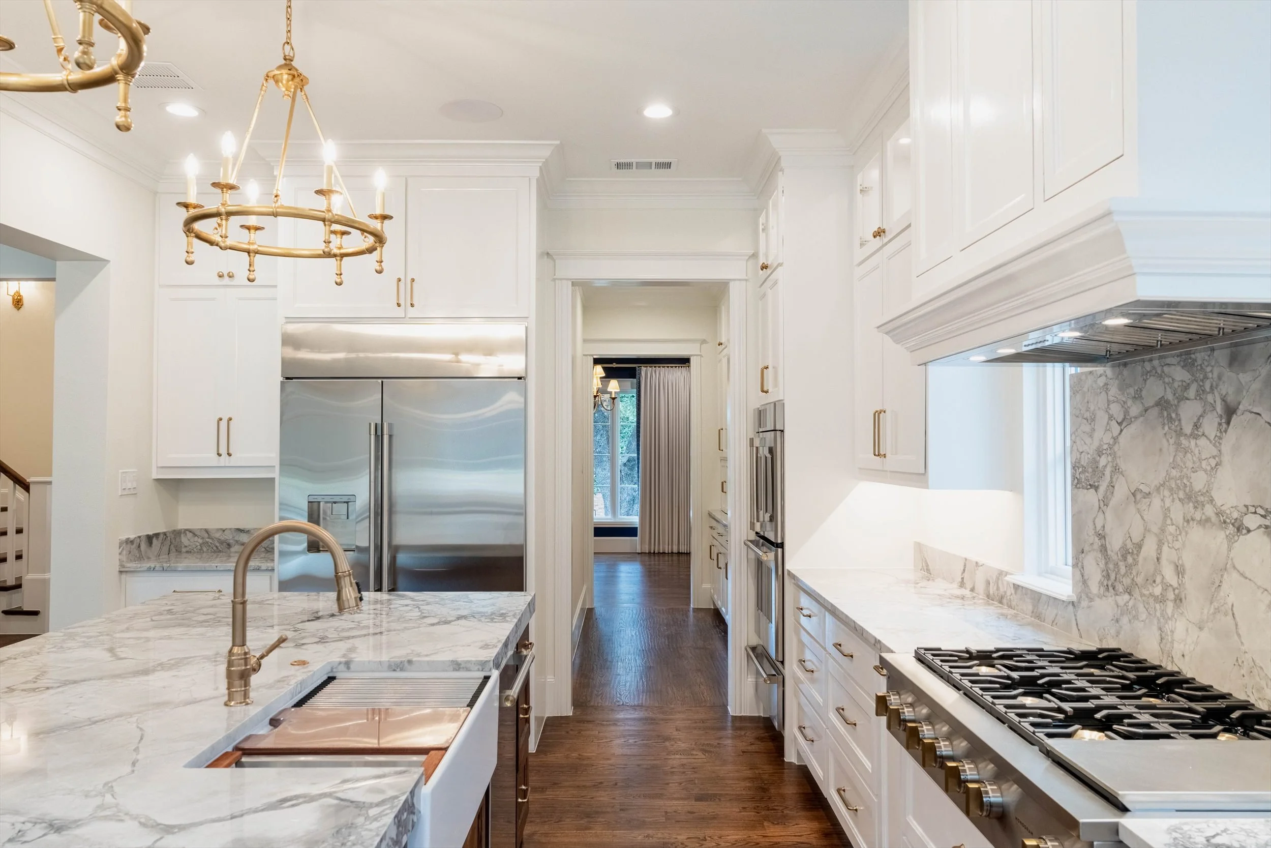 Kitchen with a marble island, white cabinetry and a range hood at 1095 Lathrop Dr.