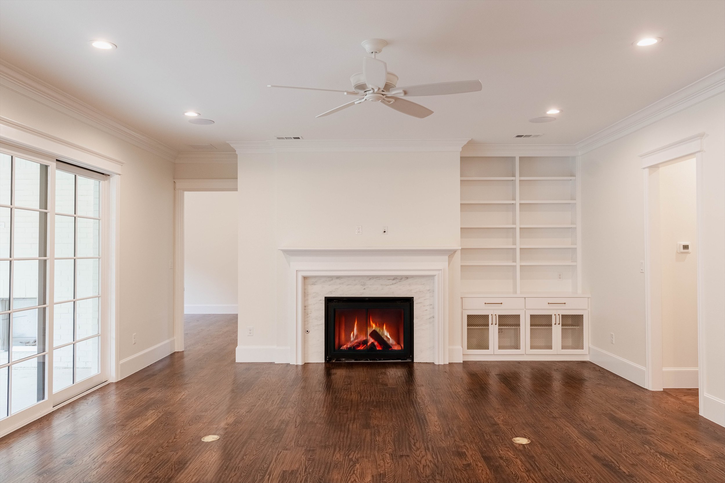 Living room with a fireplace, built-in shelving and wood flooring at 1095 Lathrop Dr.