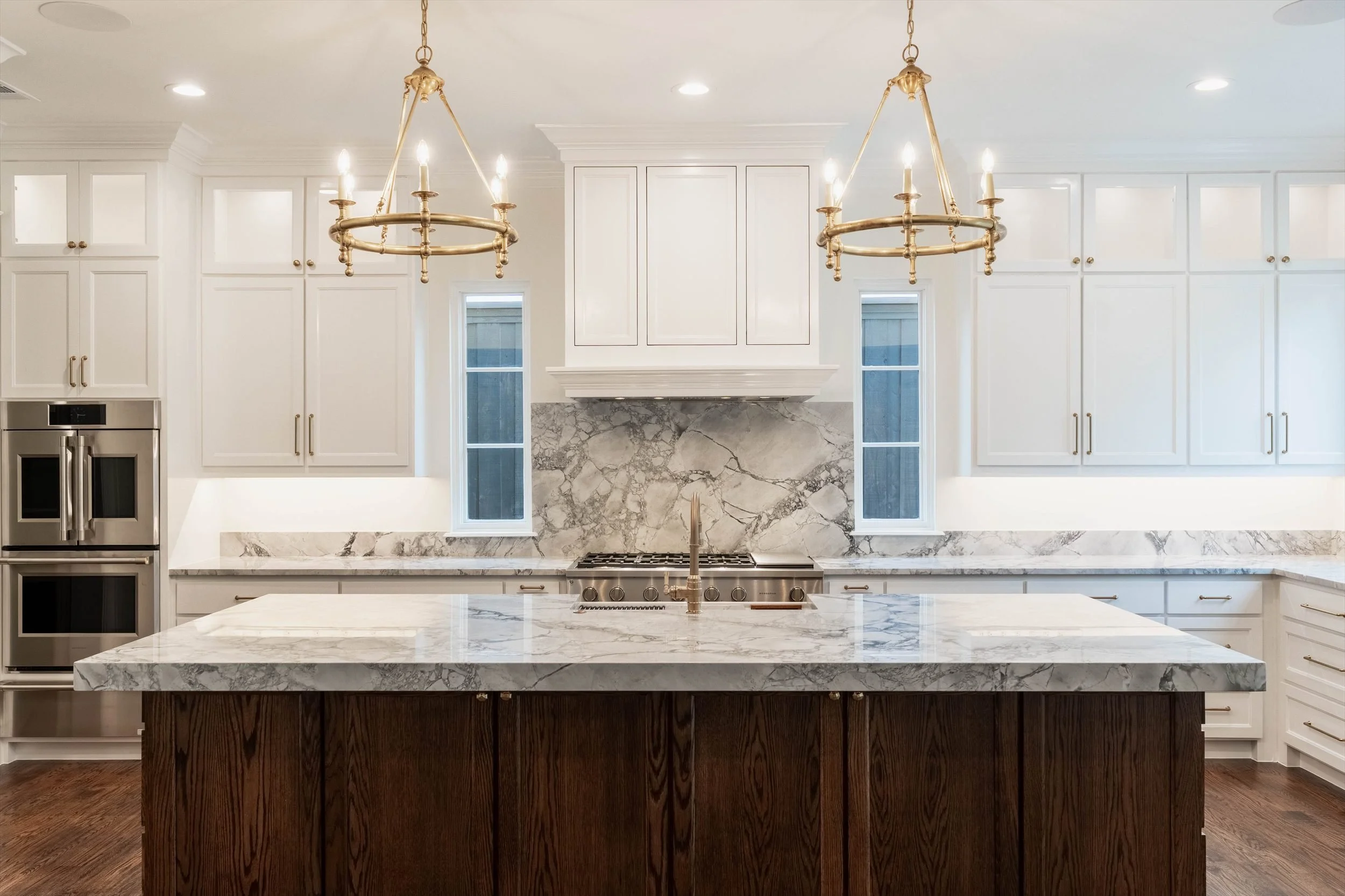 Kitchen with white cabinetry, a dark island and pendant lights at 1095 Lathrop Dr.