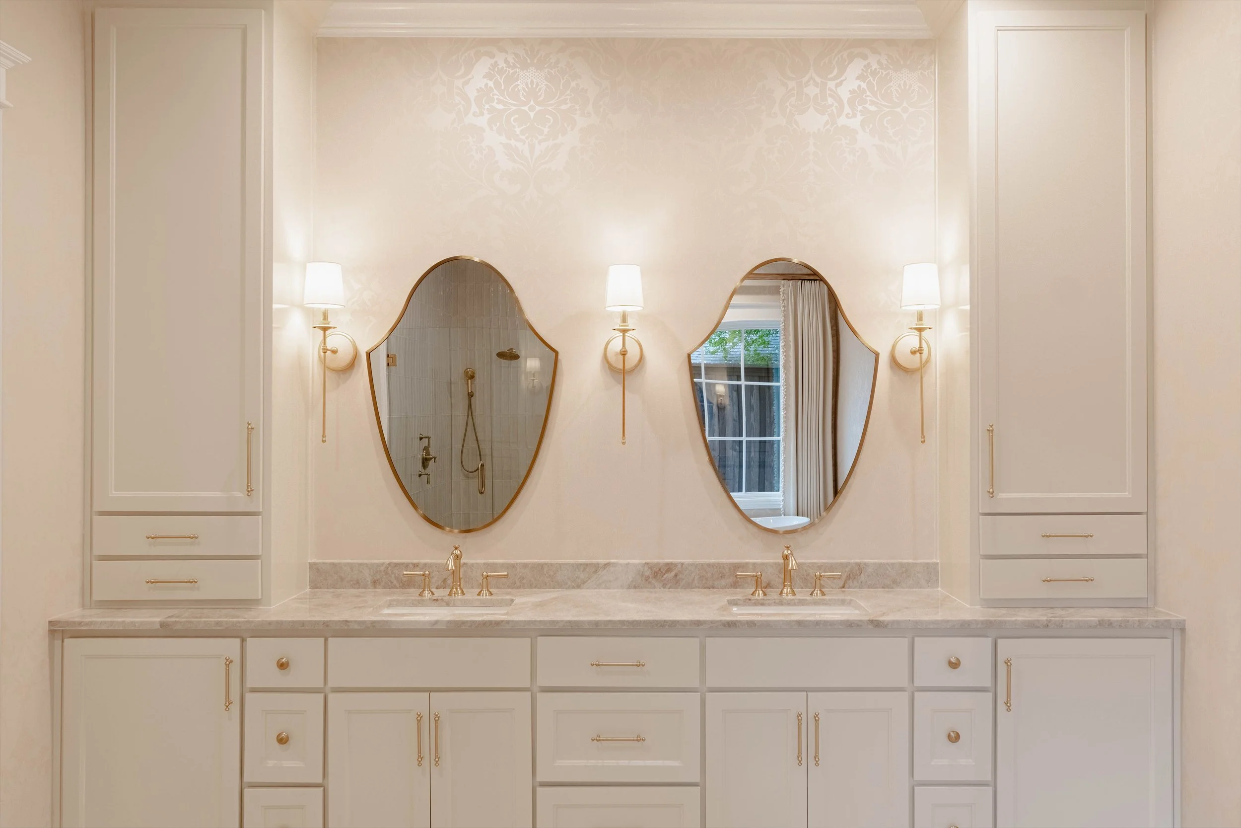 Bathroom double vanity with oval mirrors and wall sconces at 1095 Lathrop Dr.