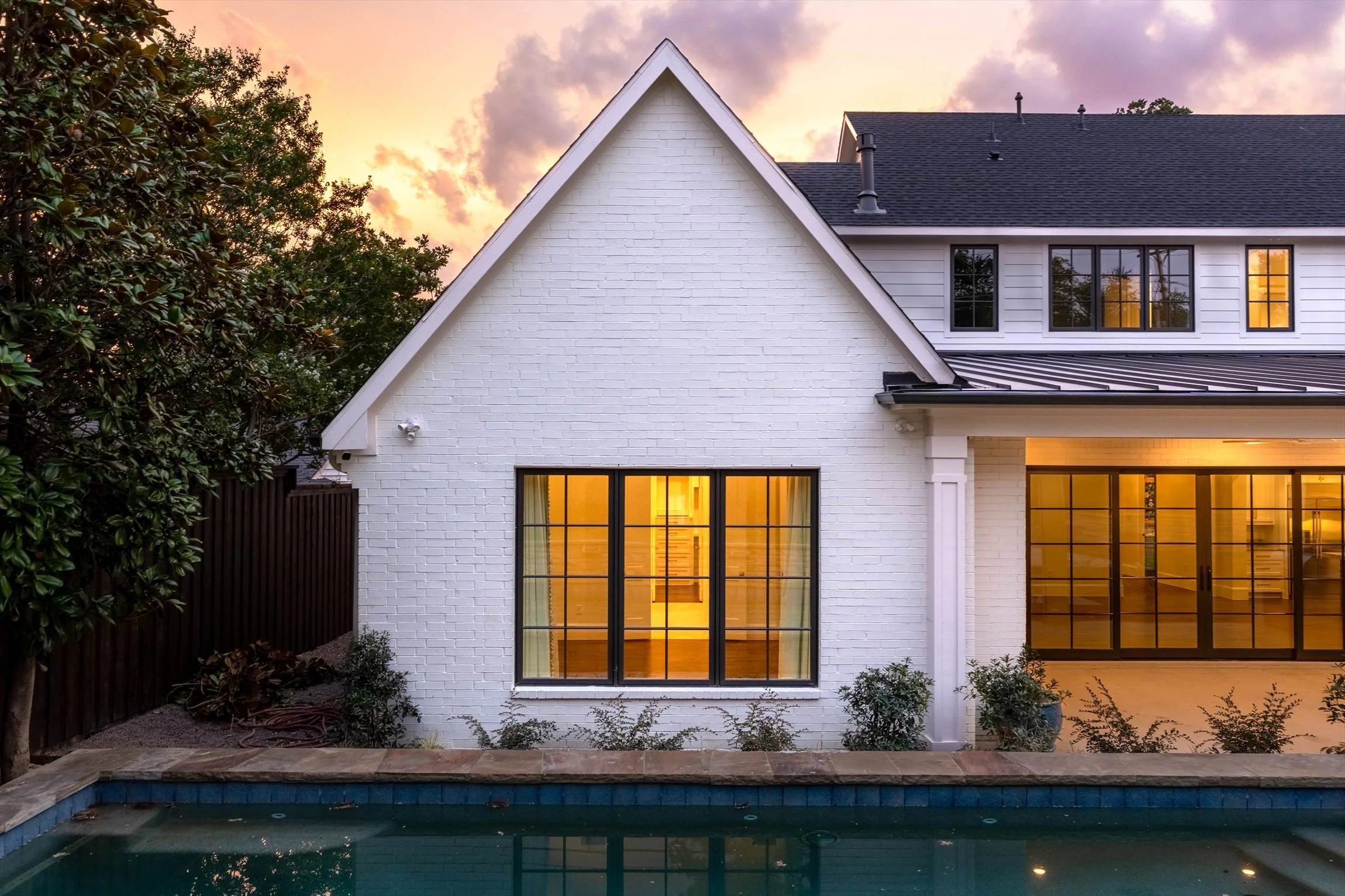 White rear exterior beside the swimming pool at dusk at 1095 Lathrop Dr.