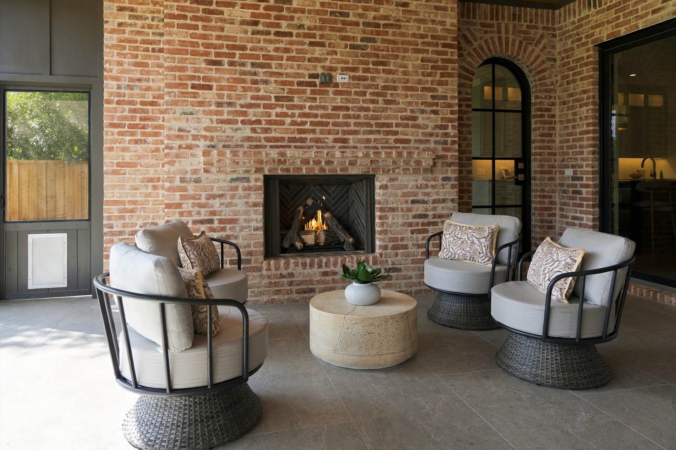 Covered patio seating with brick fireplace at 3368 Dorado Beach Dr in Dallas, Texas.