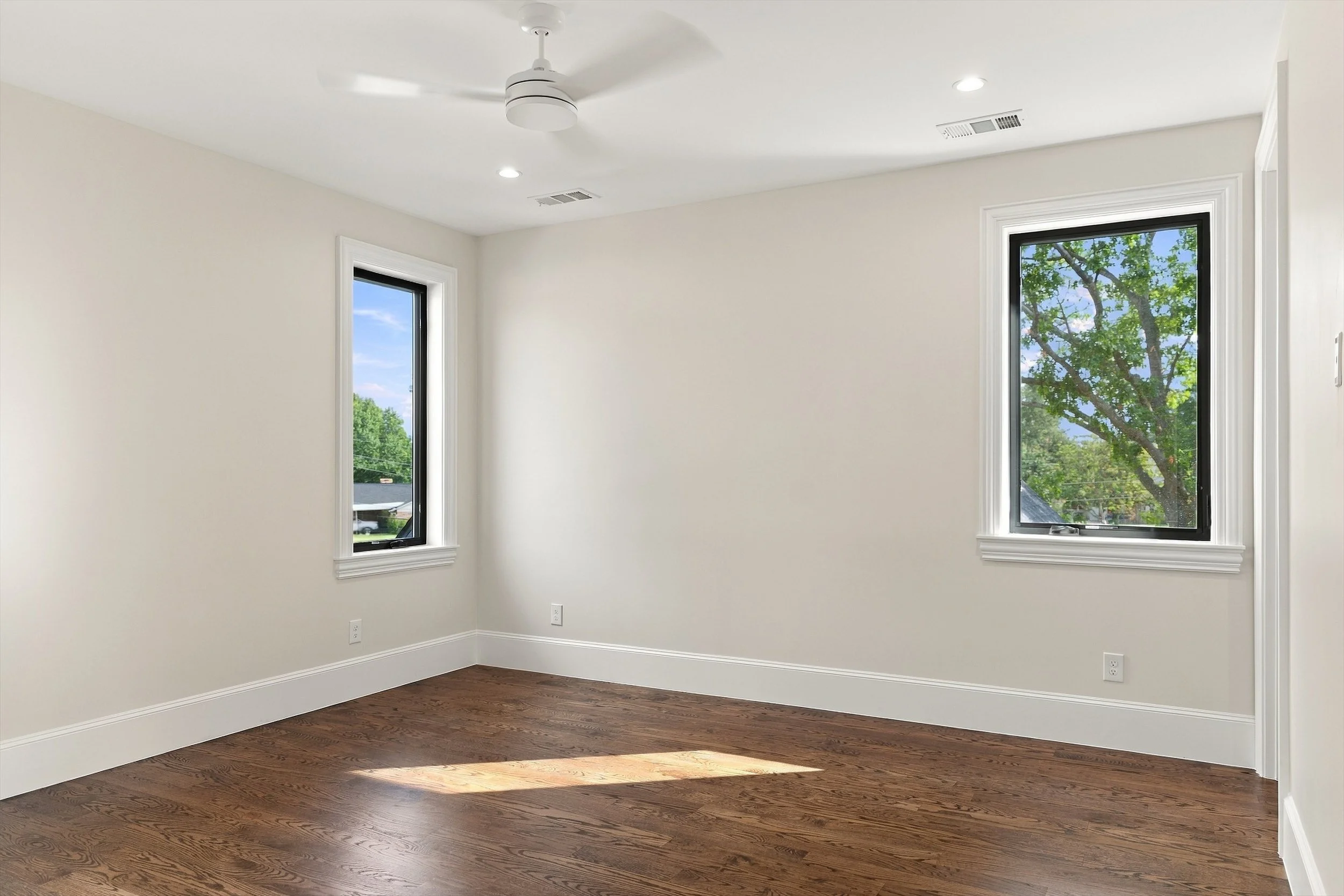 Flexible room with wood flooring and two windows at 3368 Dorado Beach Dr in Dallas, Texas.