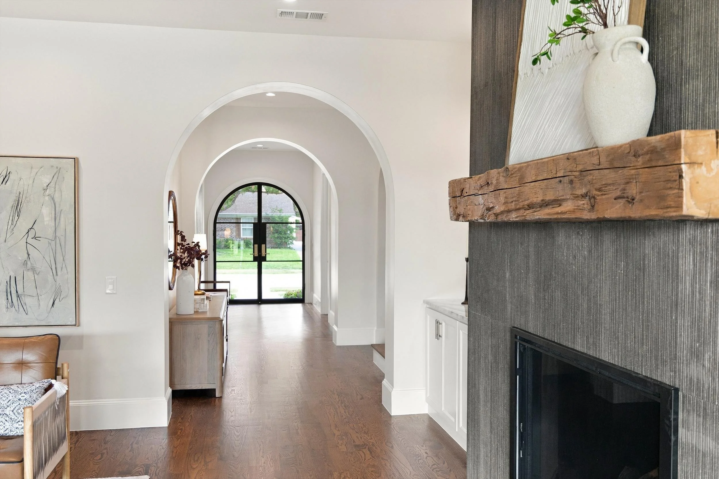 Living room fireplace and arched entry hallway at 3368 Dorado Beach Dr in Dallas, Texas.