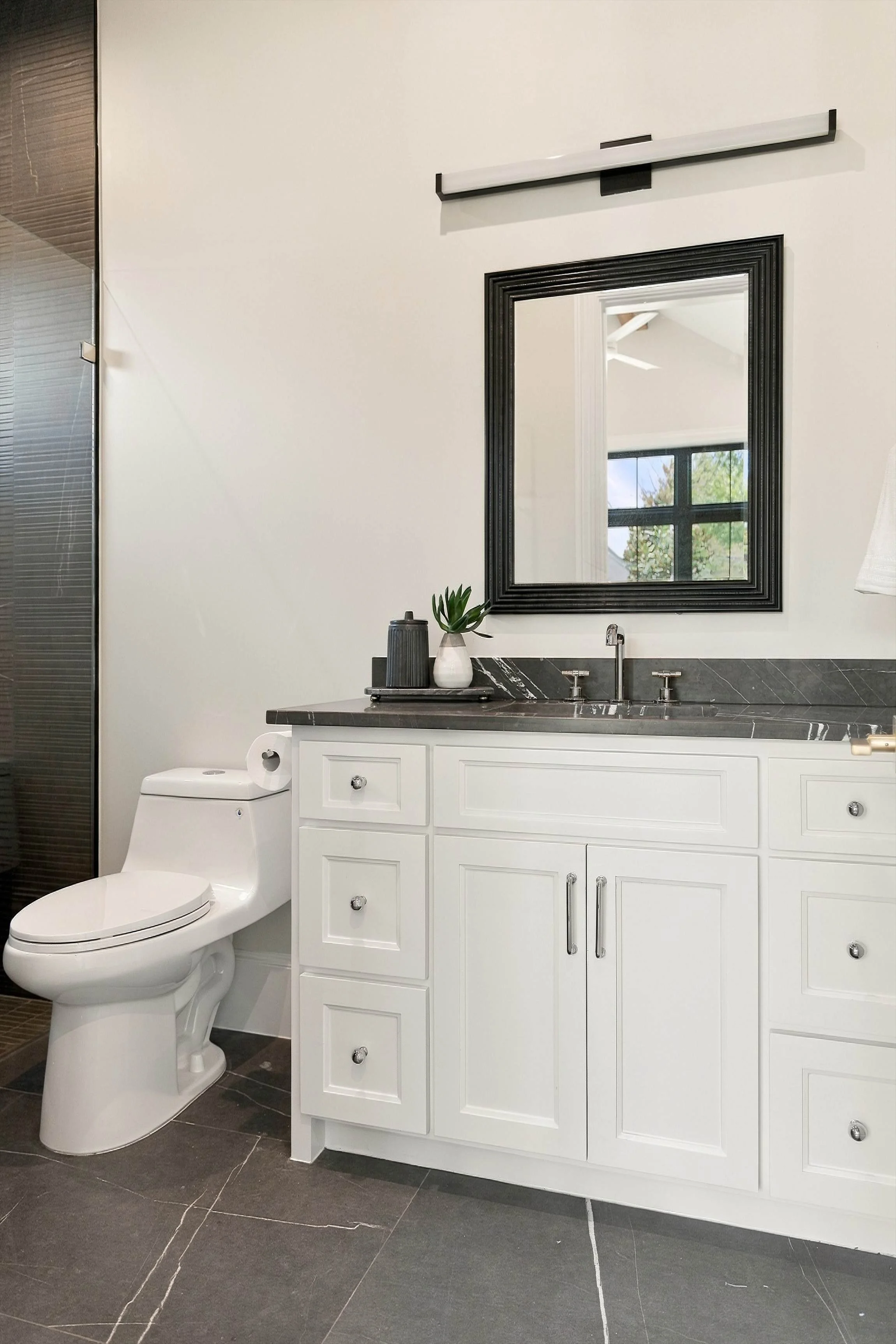 Powder room with white vanity and dark accent wall at 3368 Dorado Beach Dr in Dallas, Texas.