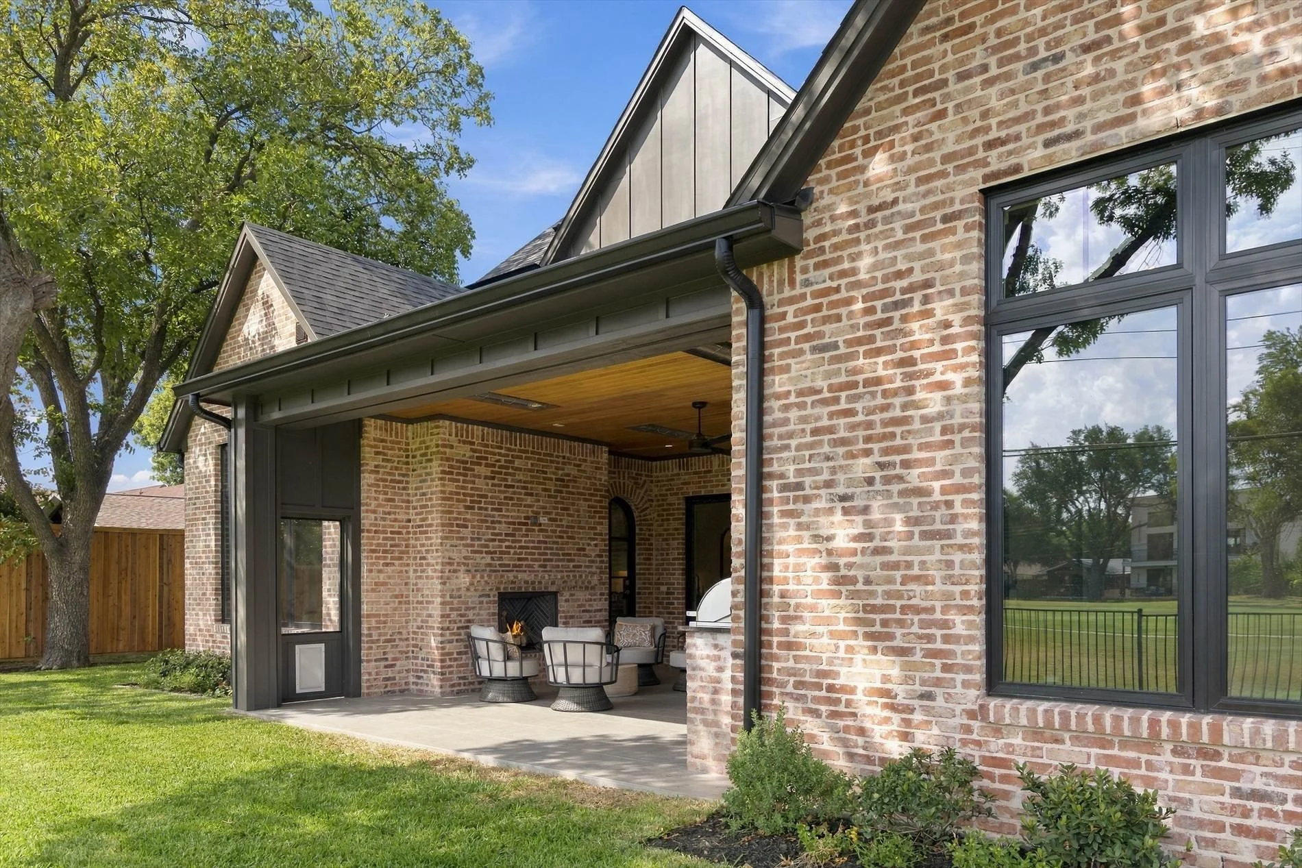 Rear exterior with covered patio and lawn at 3368 Dorado Beach Dr in Dallas, Texas.