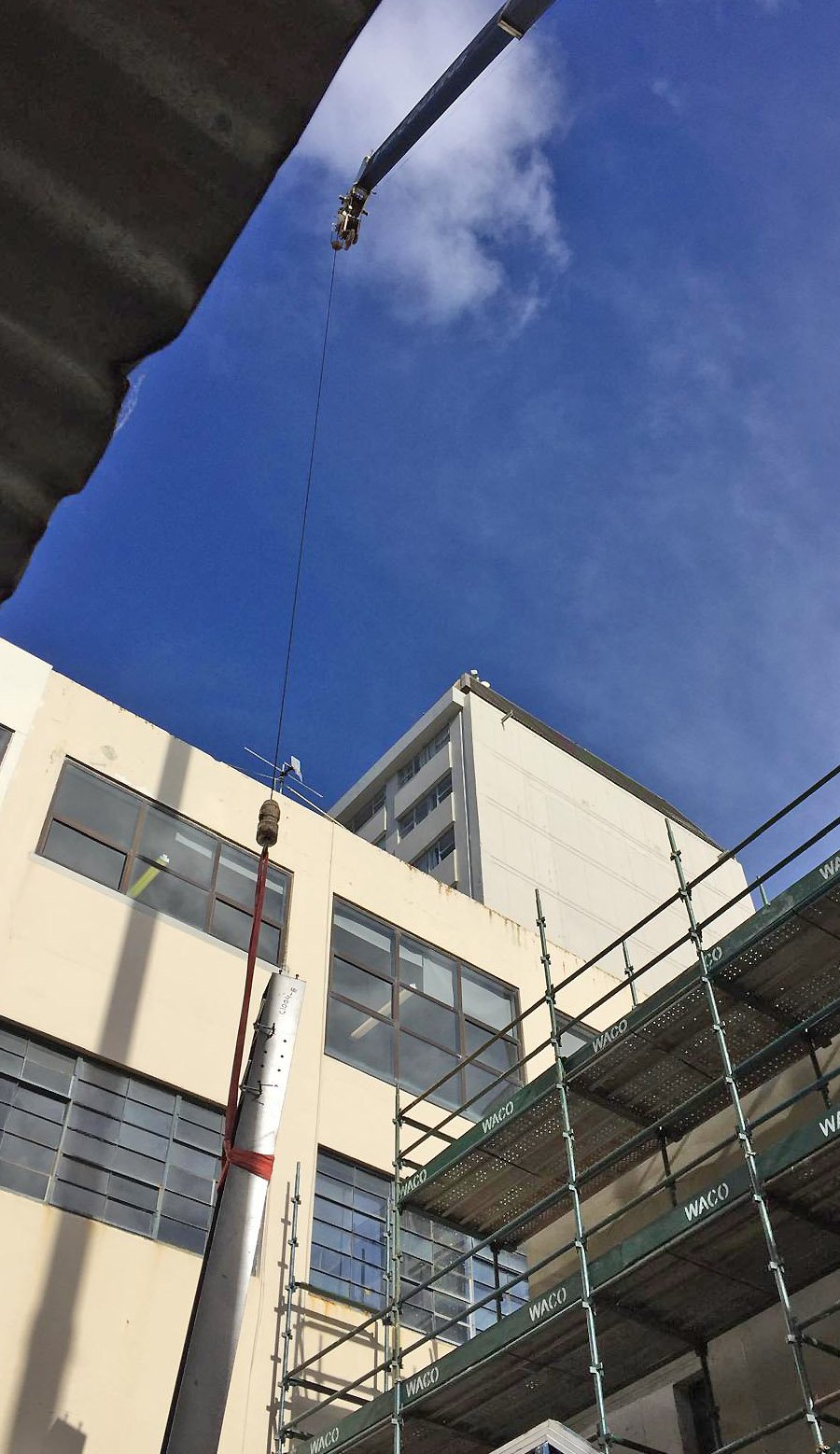 Structural steel being lifted by crane into position on a building site fabricated by Wells Engineering
