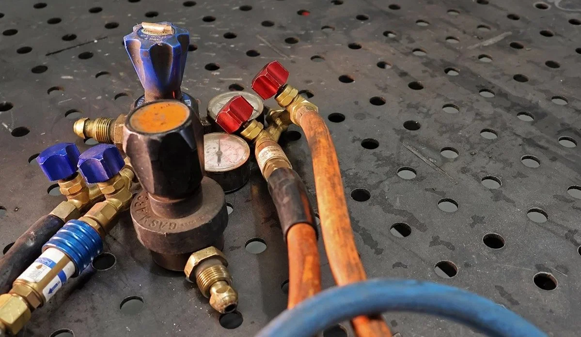 MIG welding gas regulators, hoses and equipment prepared for professional metal fabrication work.