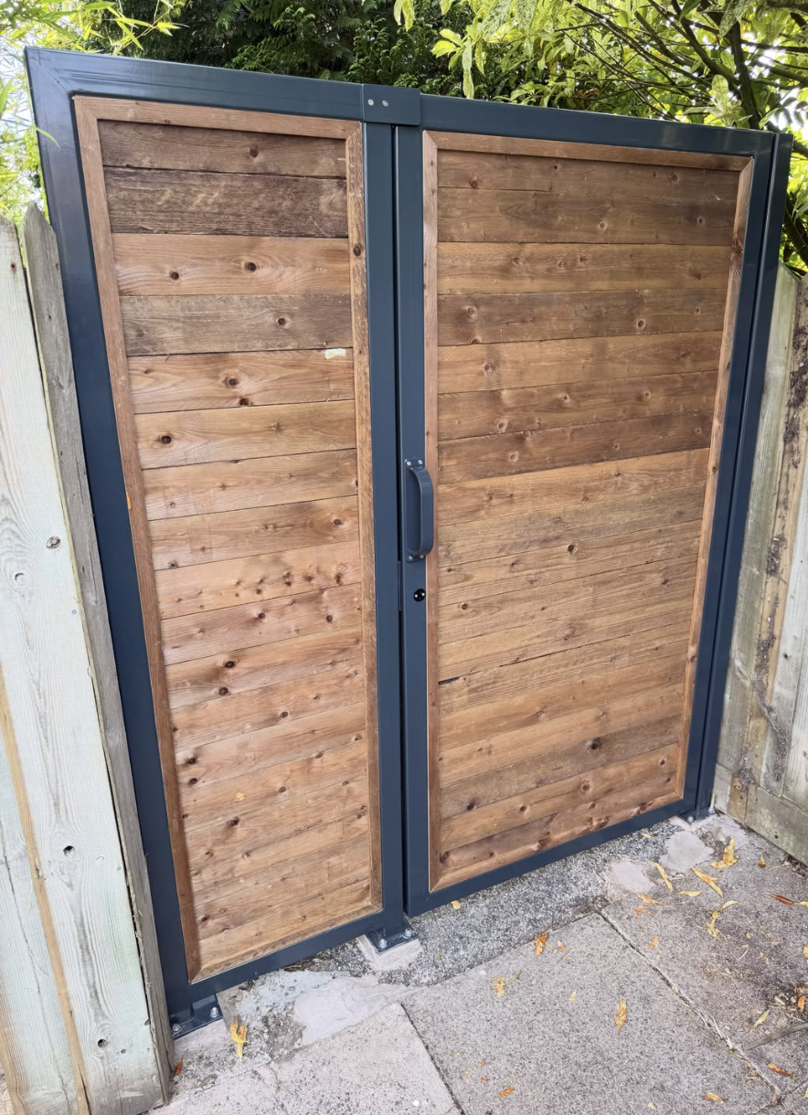 Bespoke designed powder coated steel and timber gates at a domestic residence fabricated at Wells Engineering.