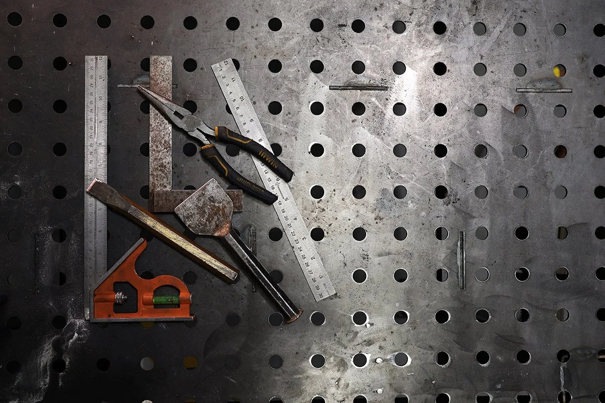 Engineering tools and steel fabrication equipment on a professional welding table at Wells Engineering.