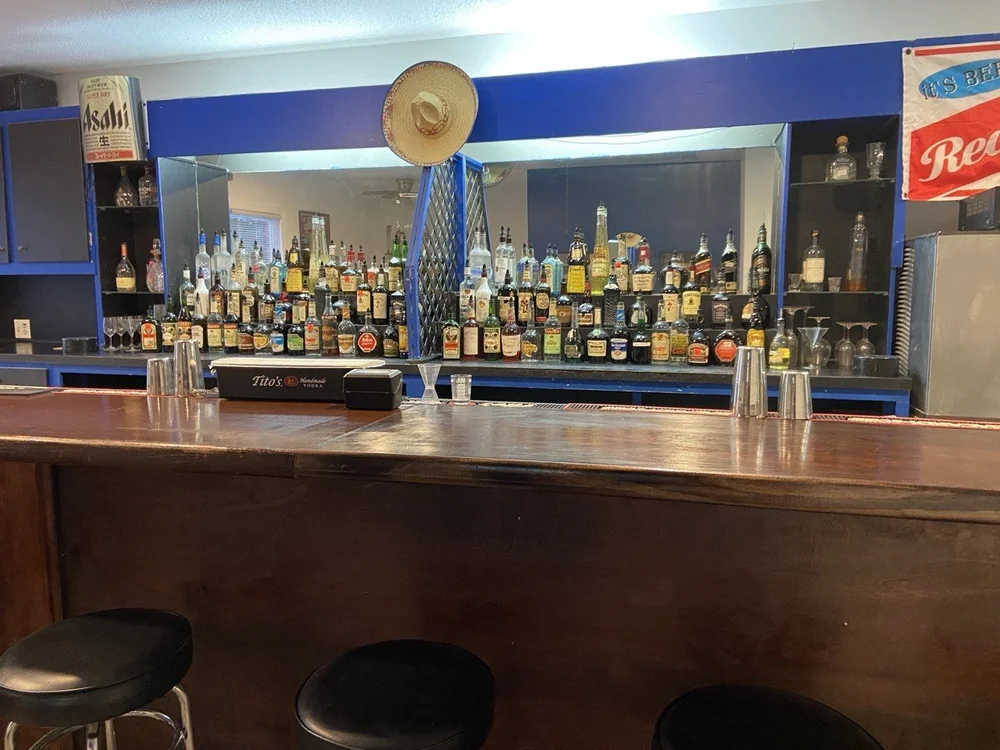 The back bar seen from a stool, with tiered shelving and mirrors.