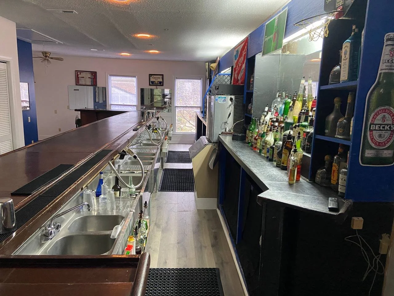The long stainless run of sinks and wells with the back bar to the right.